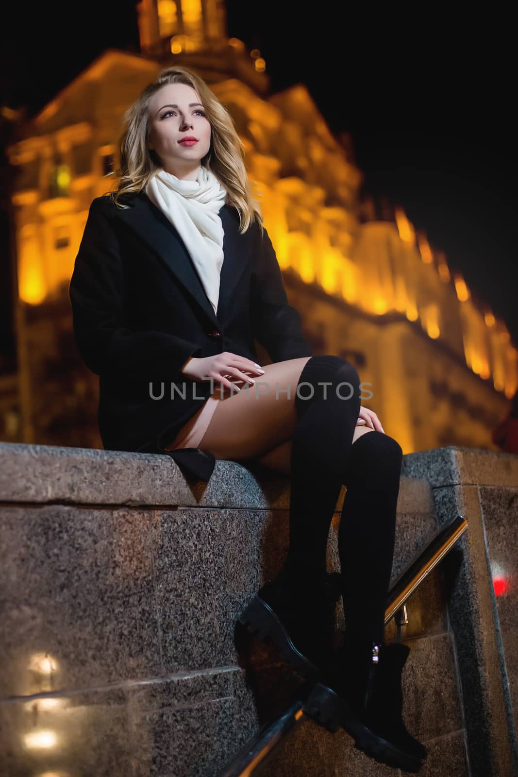 portrait of Beautiful young woman in black on a background of a night city by Nickstock