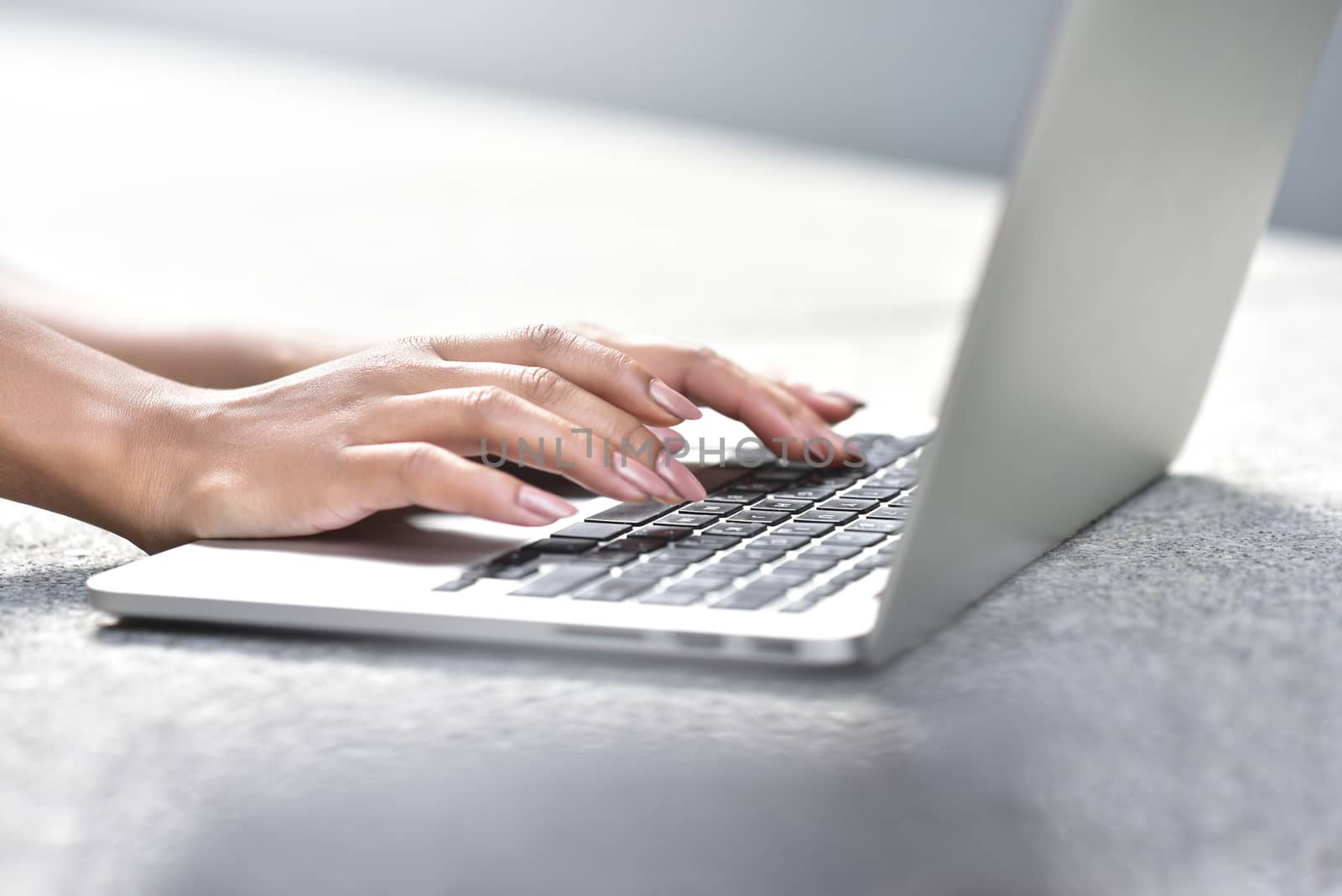 Young businesswoman sitting at street working with laptop, close-up photo. Business, education, lifestyle concept.