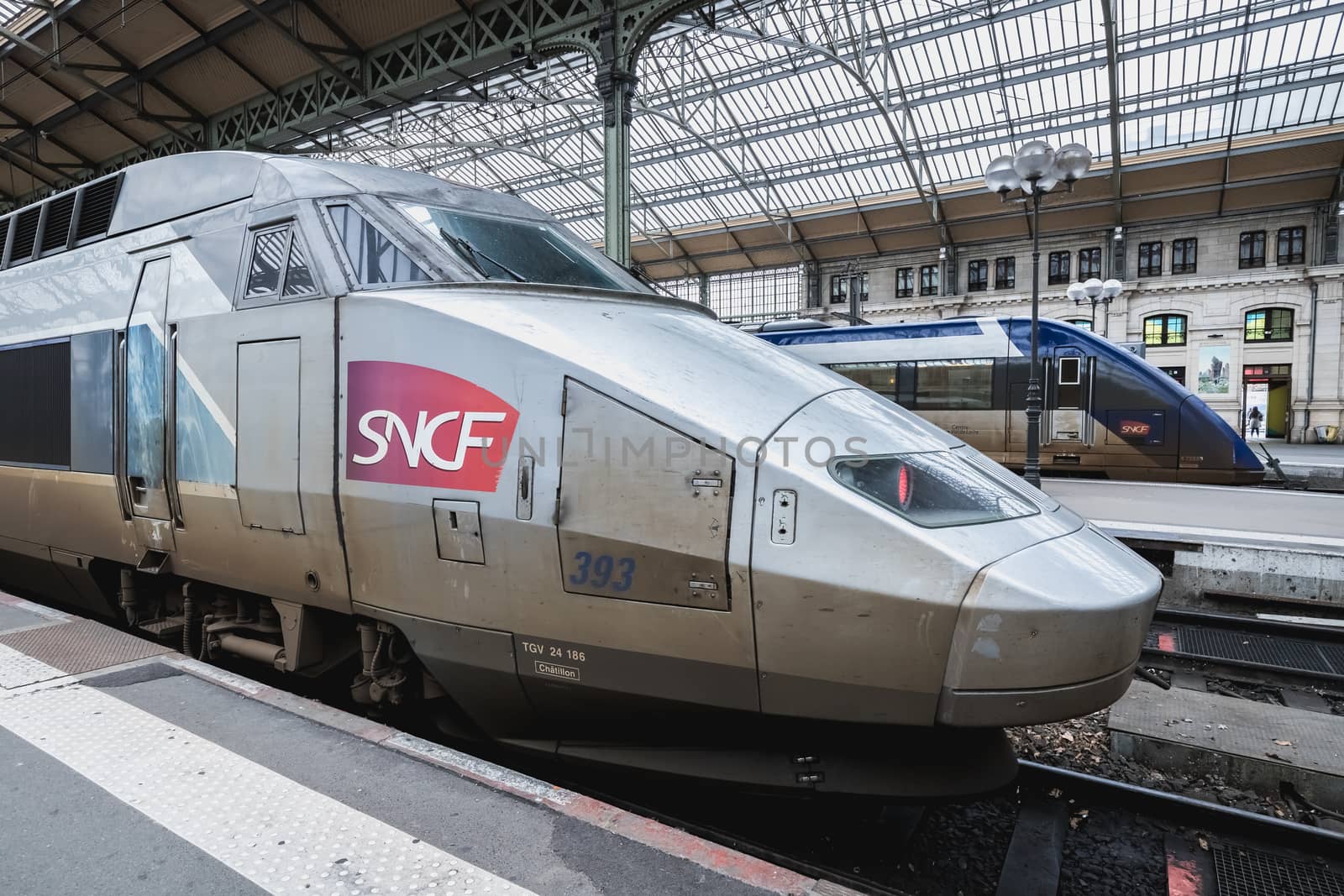 Tours, France - February 8, 2020: train at platform where people walk inside Tours train station in the city center on a winter day