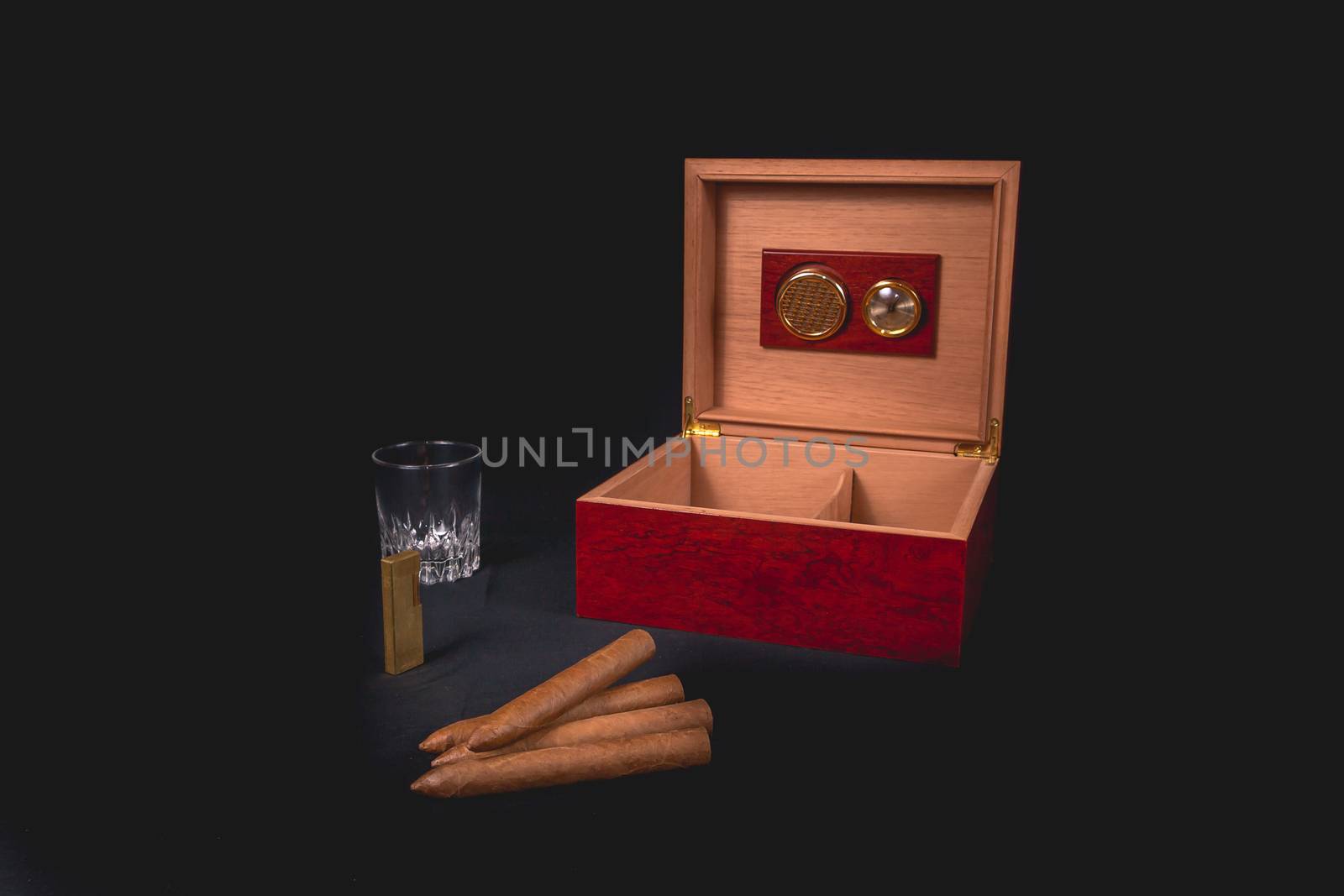 Cigar box on black background and gold lighter