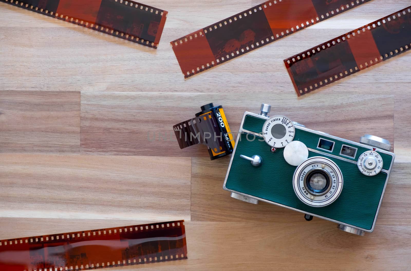 The American Film Camera Argus c3 with Kodak film and film sheet on Wooden Background