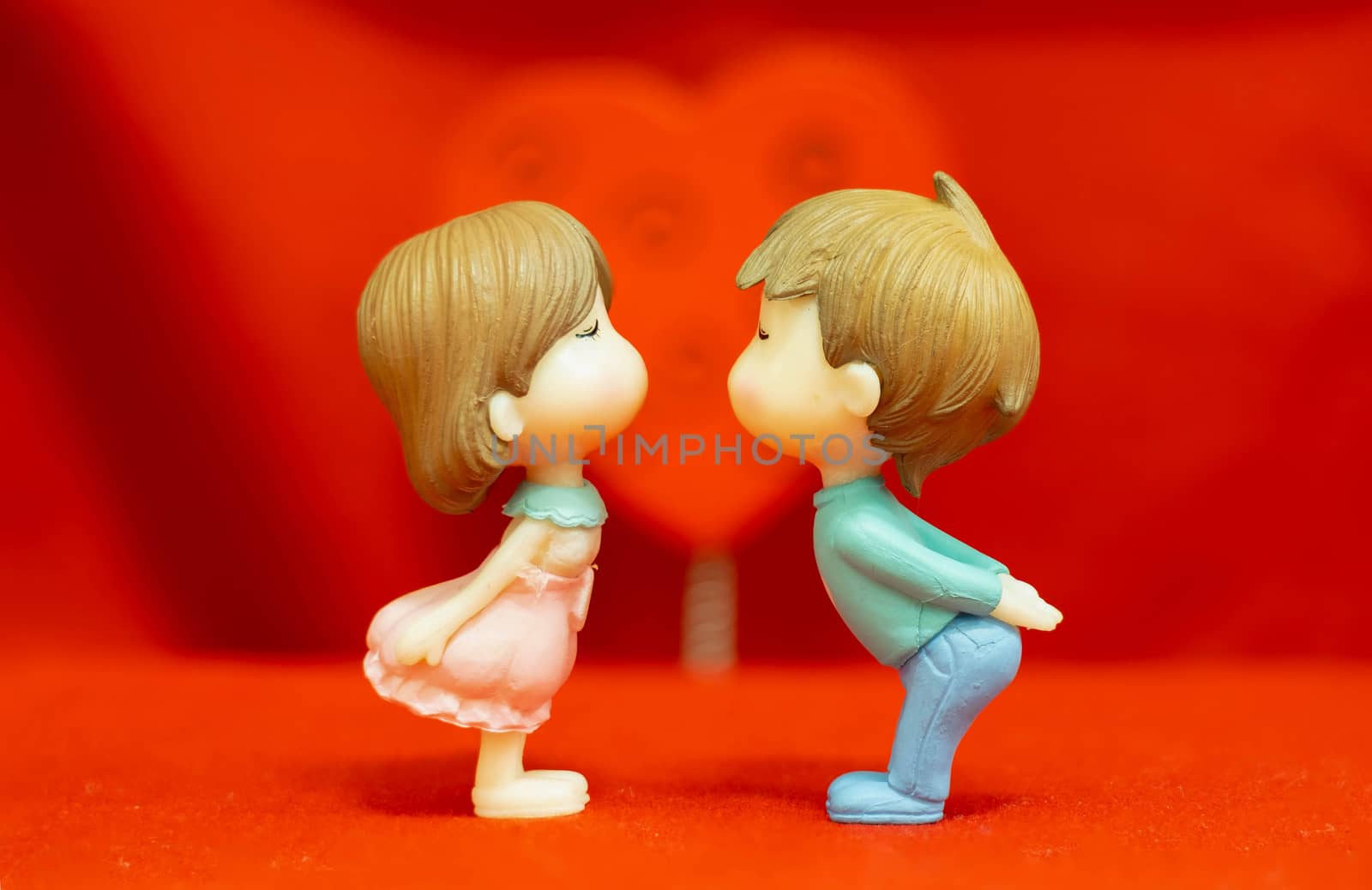 The Miniature Couple dolls Boy and Girl Romantic Kiss on Red Heart  Background for valentine's Day Concept