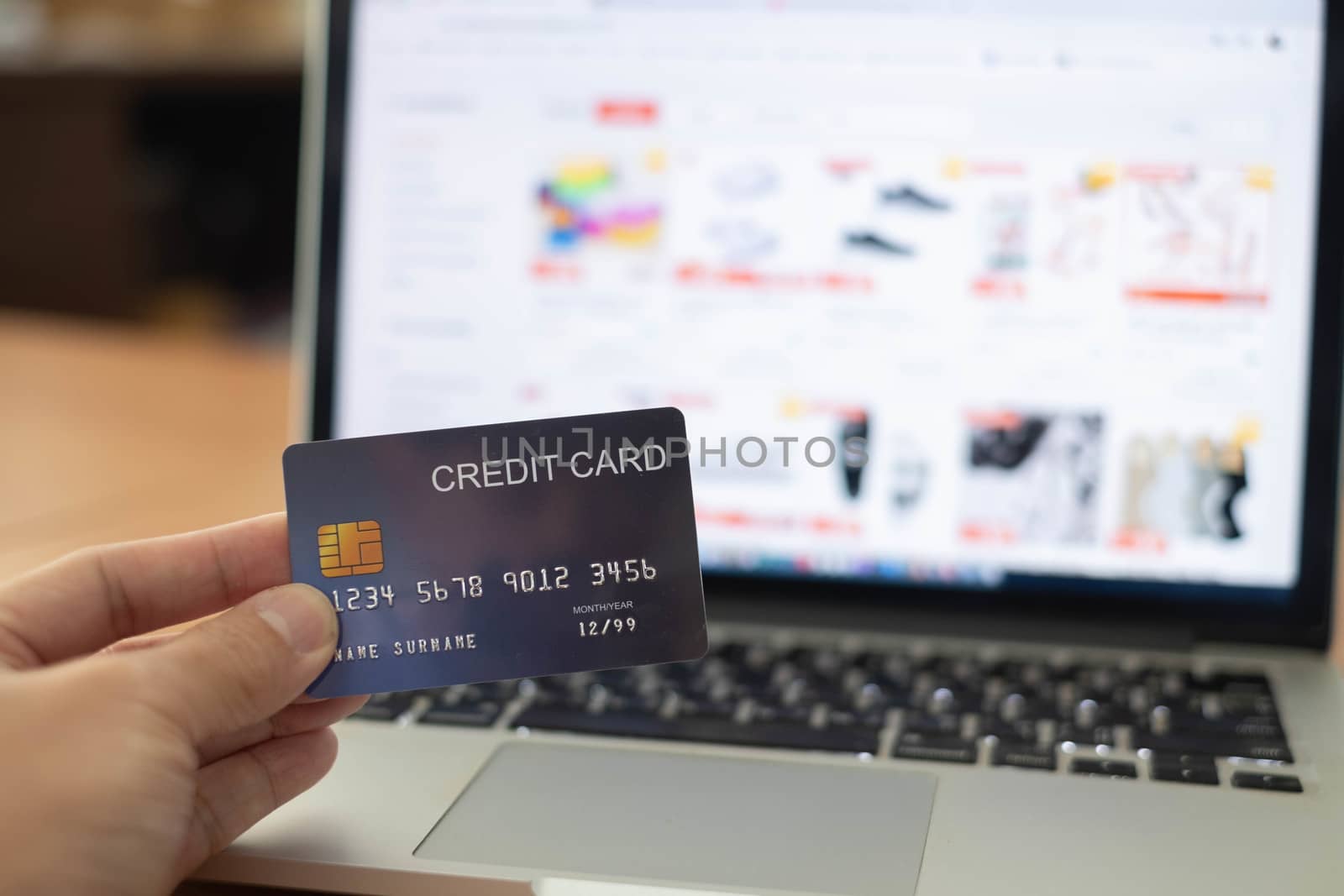 Hands holding plastic credit card and using laptop for online shopping. Online shopping concept