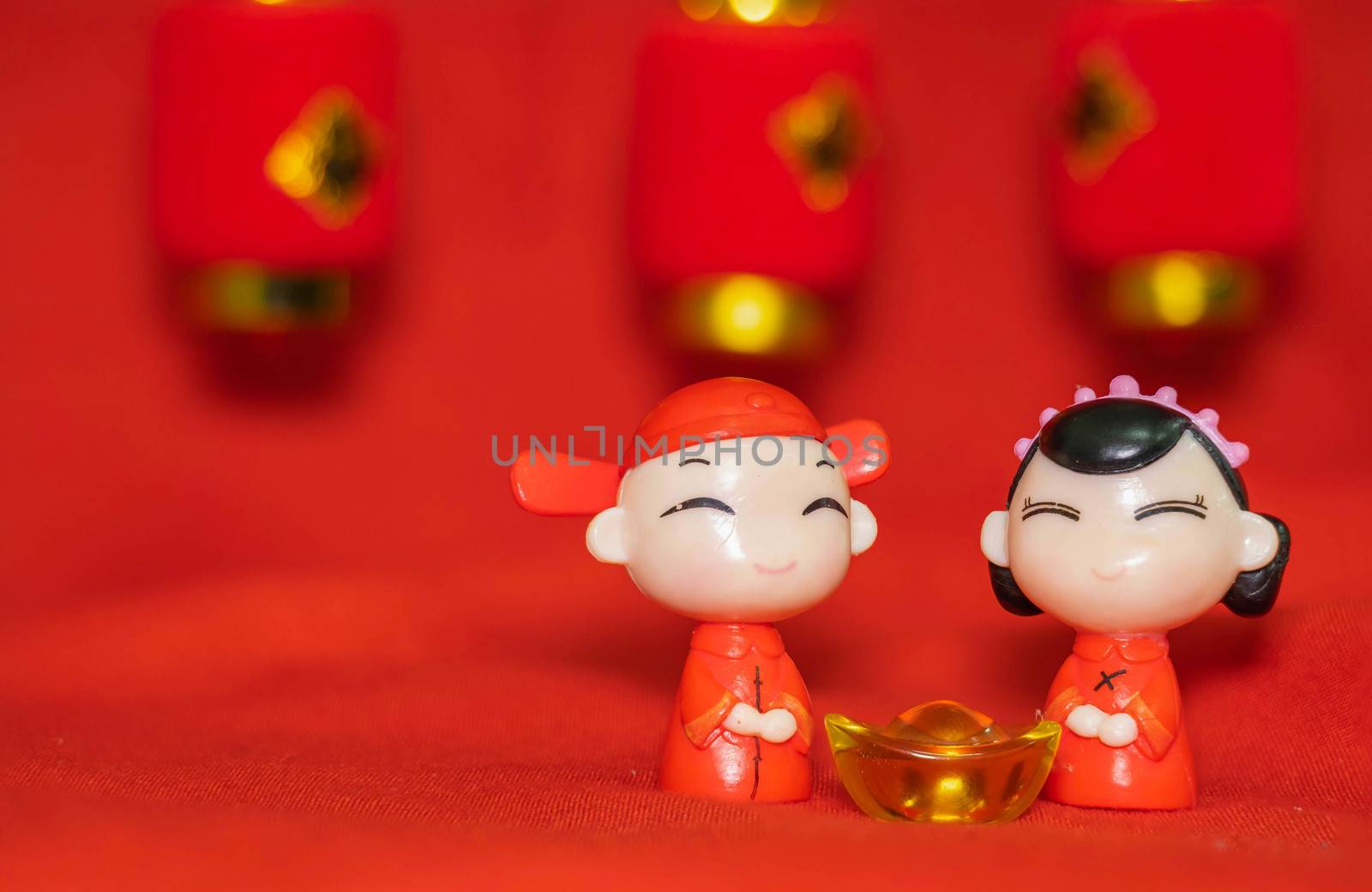 Chinese New Year decoration on a red background Chinese Couple Figure Model wish for a Luck  and lump of gold and a Chinese Word on Lantern said Luck