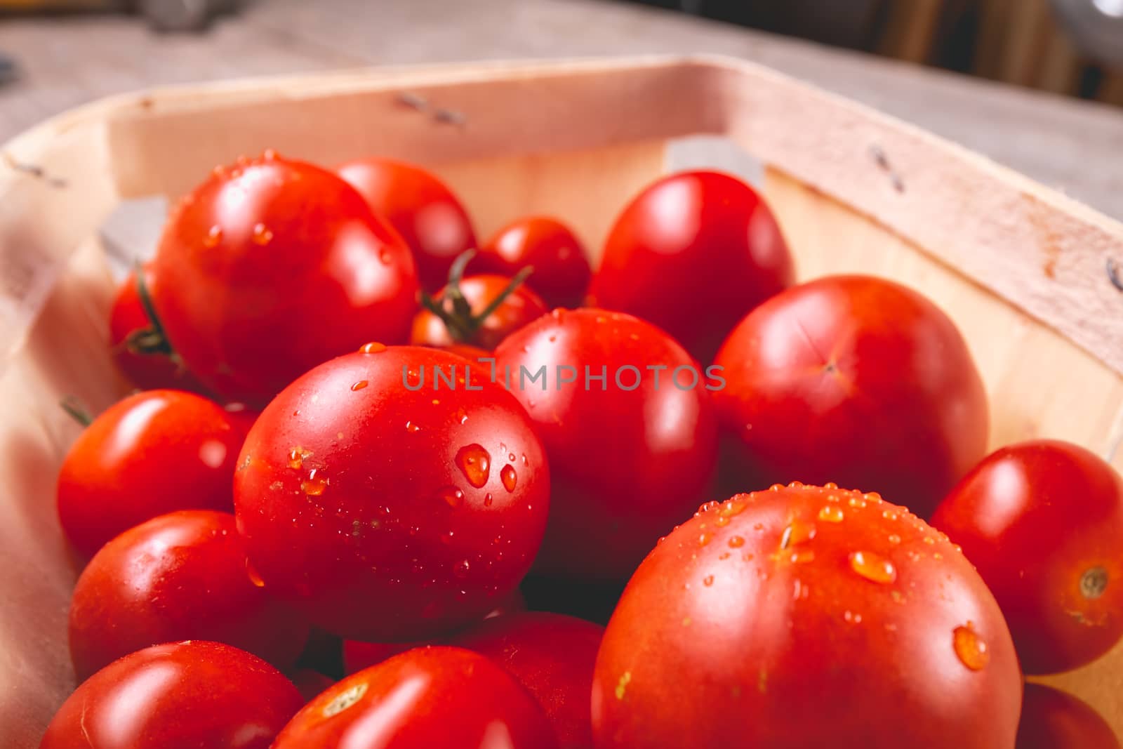 ripe tomatoes in a small wooden crate in studio