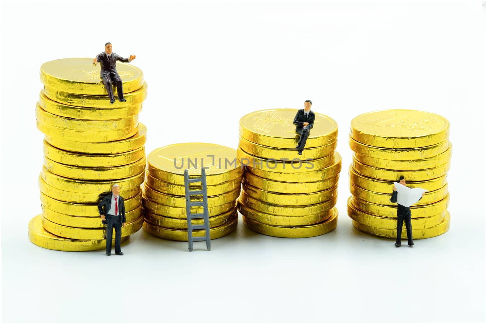 miniature figure a group of business men sitting on top of pile stack of golden coins and some standing reading newspaper and discuss to other   business success concept