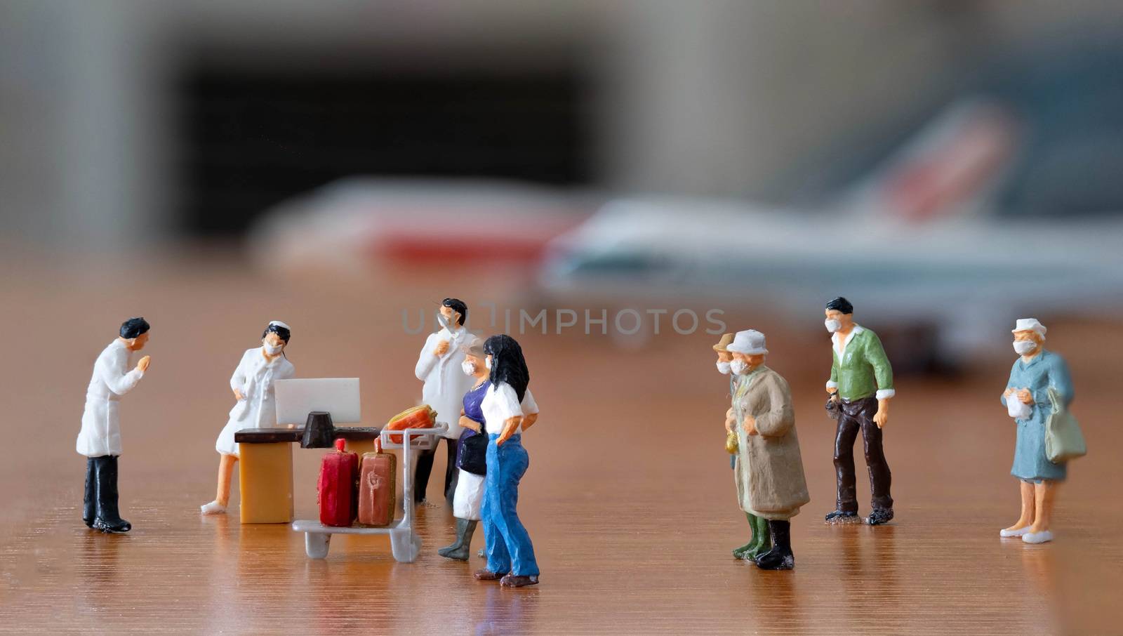 miniature figure doll passenger in airport wearing mask to protect Coronavirus or Covid-19 walking to Disease Contro; point that have Doctor and nurse