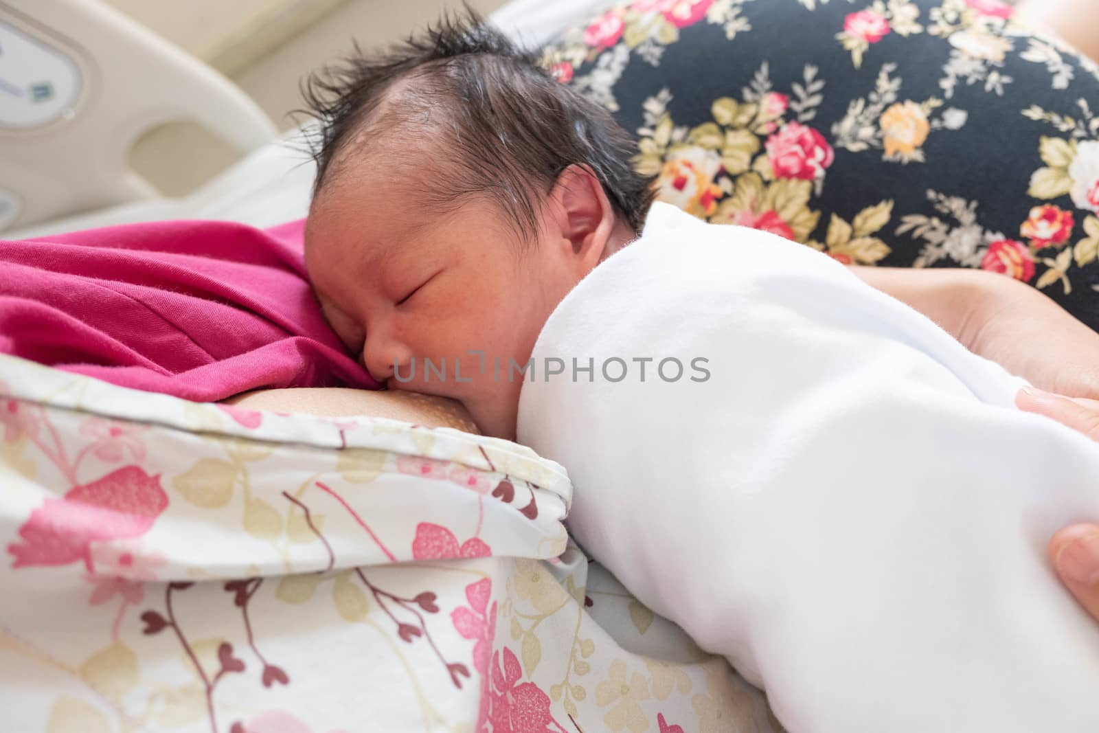 Feeding mother breast milk with the  new born baby on hands