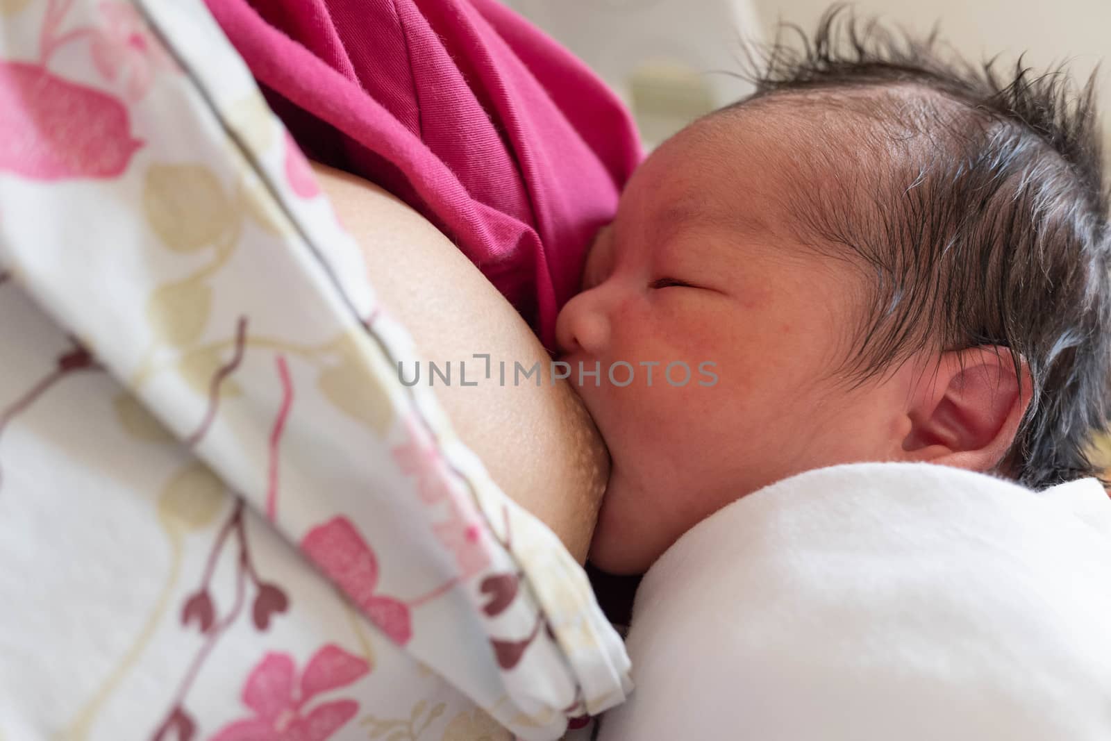 Feeding mother breast milk with the  new born baby on hands