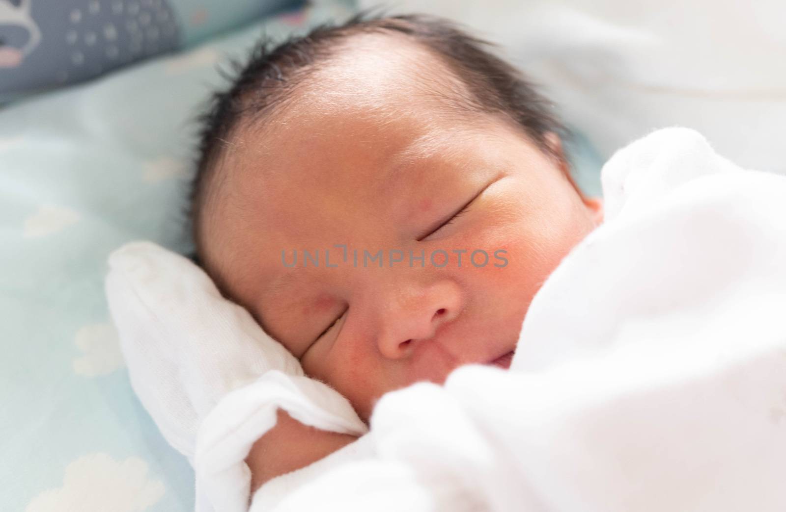 The Sleeping cute New Born Baby infant on the bed