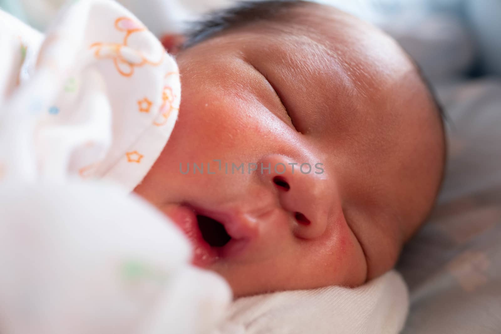 Sleeping cute New Born Baby infant with white baby cloth on the bed