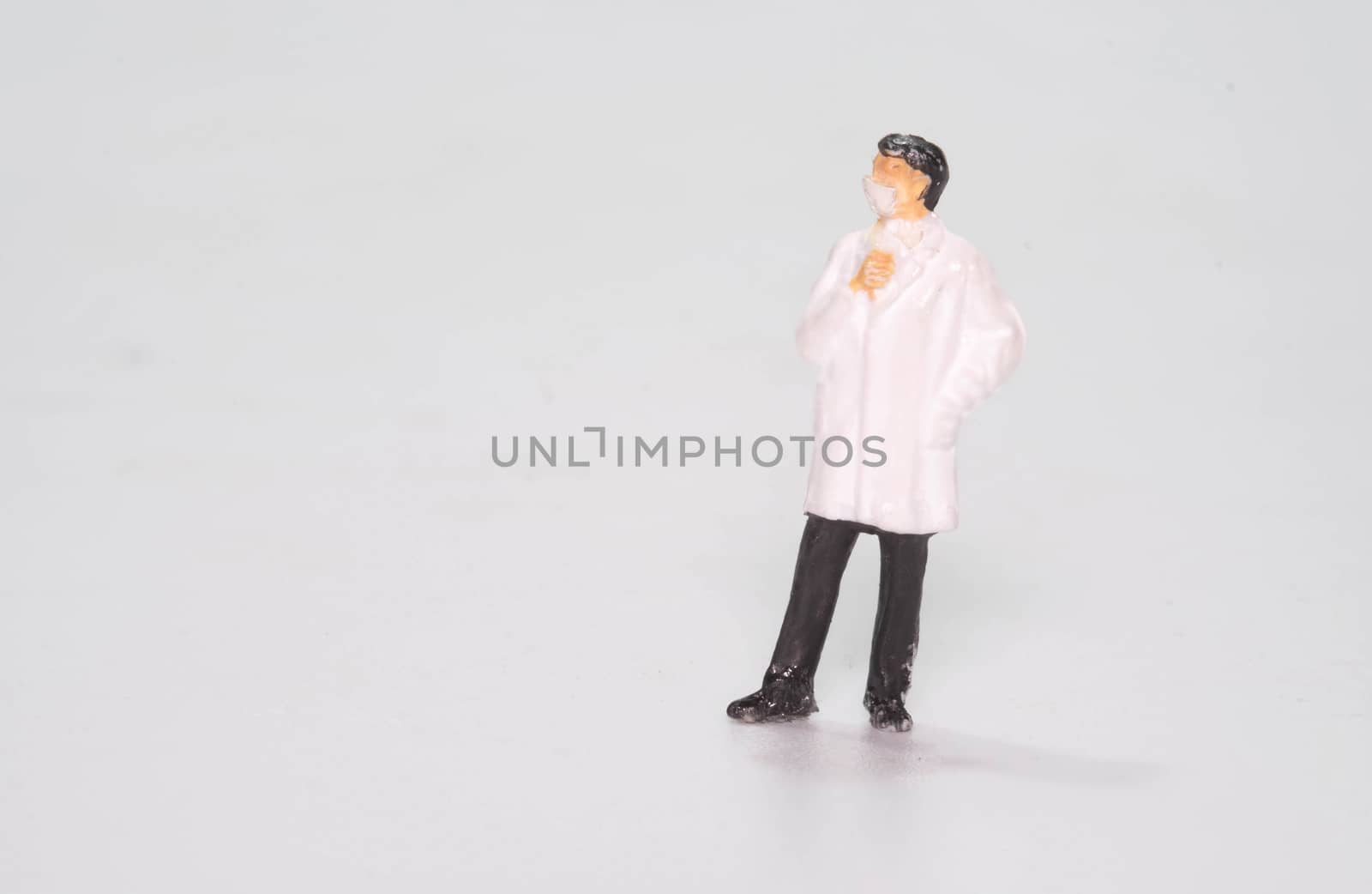 the miniature fifure doll doctor wearing face mask isolated on white background