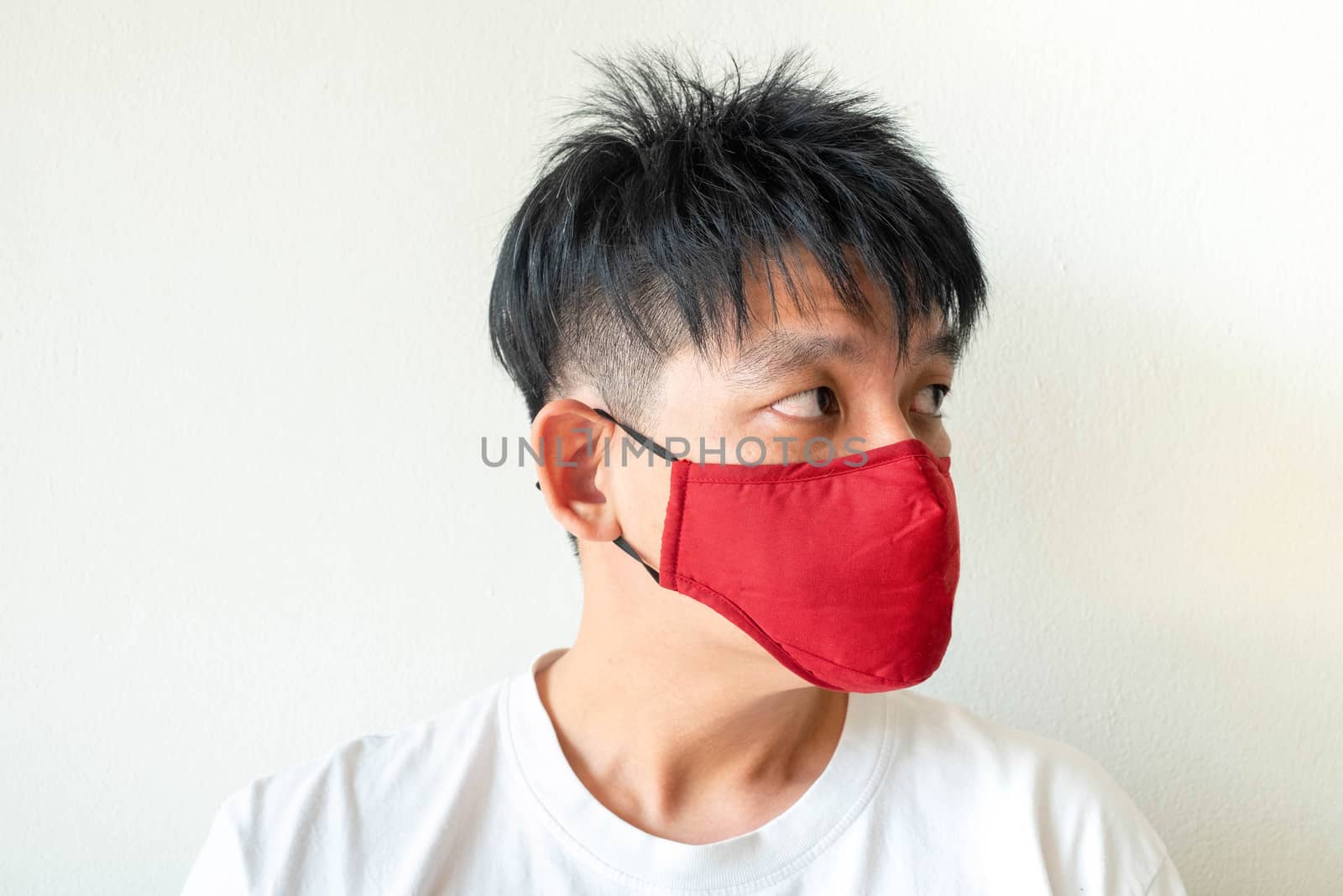 Face of Asian Man Wearing Face Mask to protect himself from Coro by Bonn2210