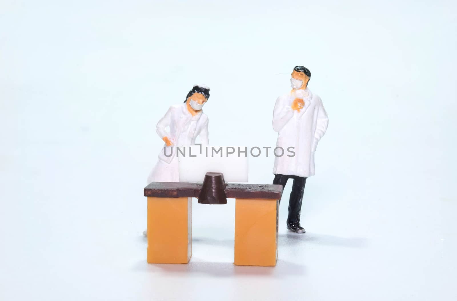 the miniature figure doll doctor and nurse wearing mask looking at display screen in disease Control point to scan Coronavirus or Covid-19