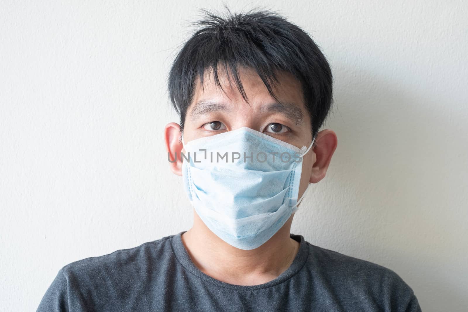 The Face of Sick Asian Chinese Man Wearing Face Mask feeling sick headache and  cough because of  Coronavirus Covid-19  Isolate on White Background