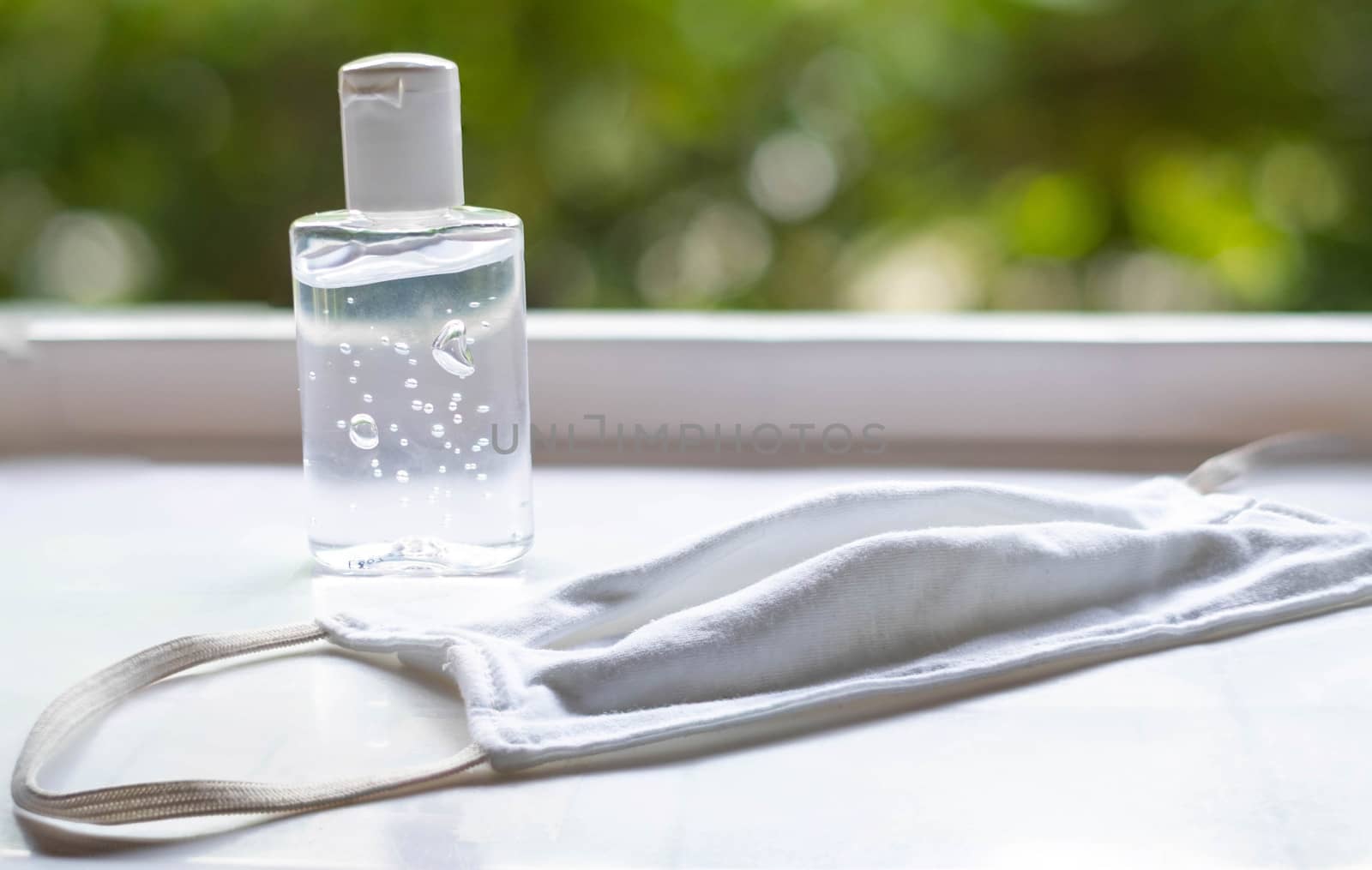 hand wash sanitizer and face mask on the white table