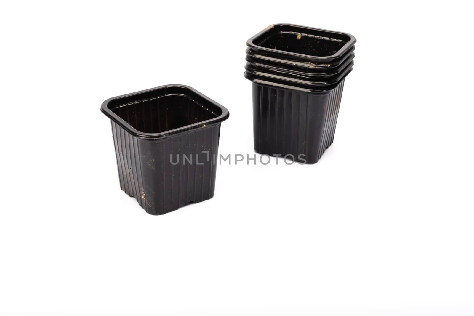 used black plastic gardening bucket waiting for spring on white background in studio