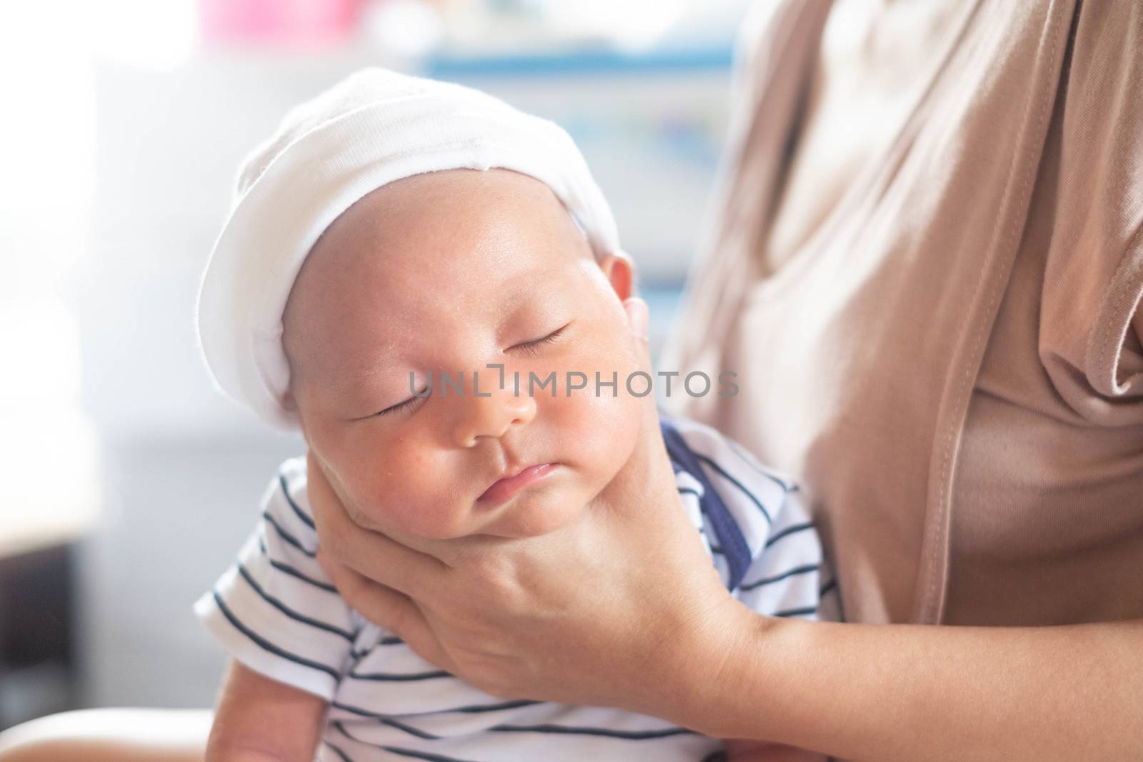 Soft focus photo of mother, mom using hand Hold baby to help a baby newborn infant belch burping after breastfeeding milk to heal gas pain or indigestion