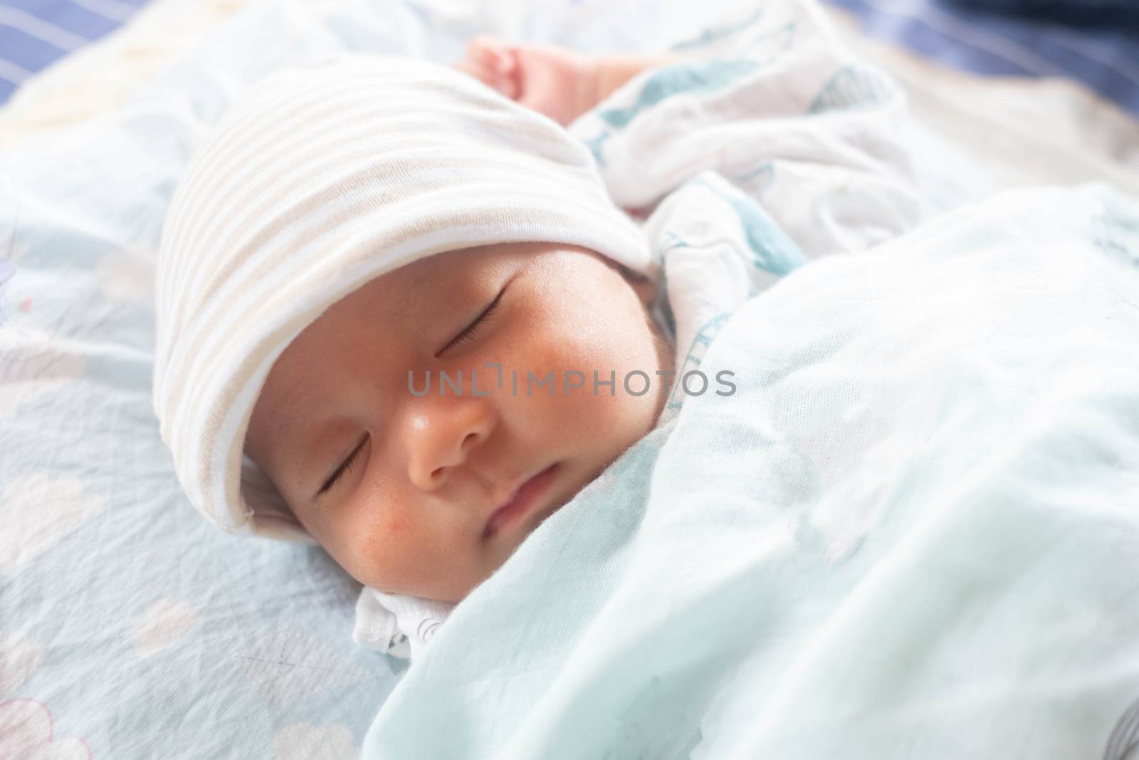 The Sleeping cute New Born Baby infant with hat  on the bed