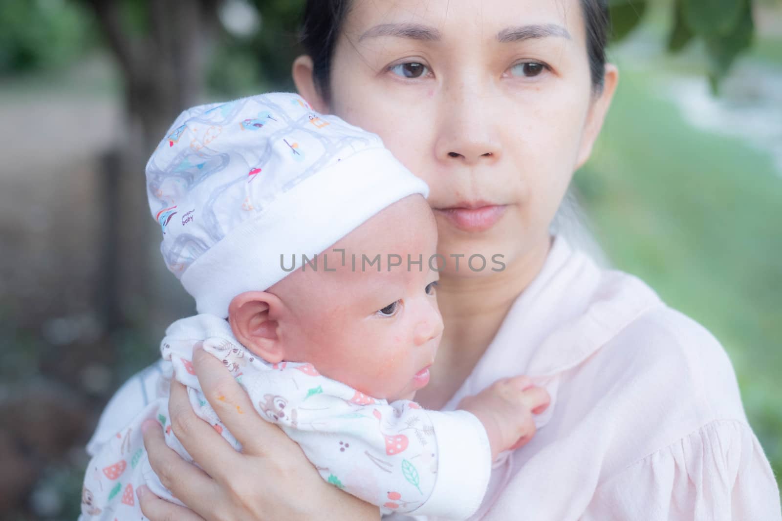 Portrait of a newborn baby infant  hold close by mother in the g by Bonn2210