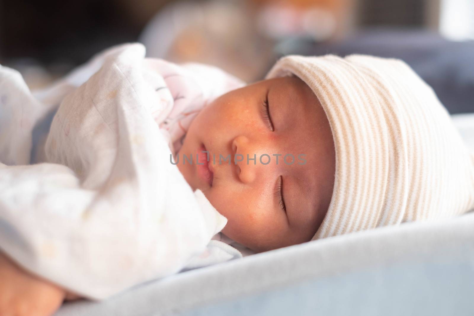 The Sleeping cute New Born Baby infant with hat on the bed