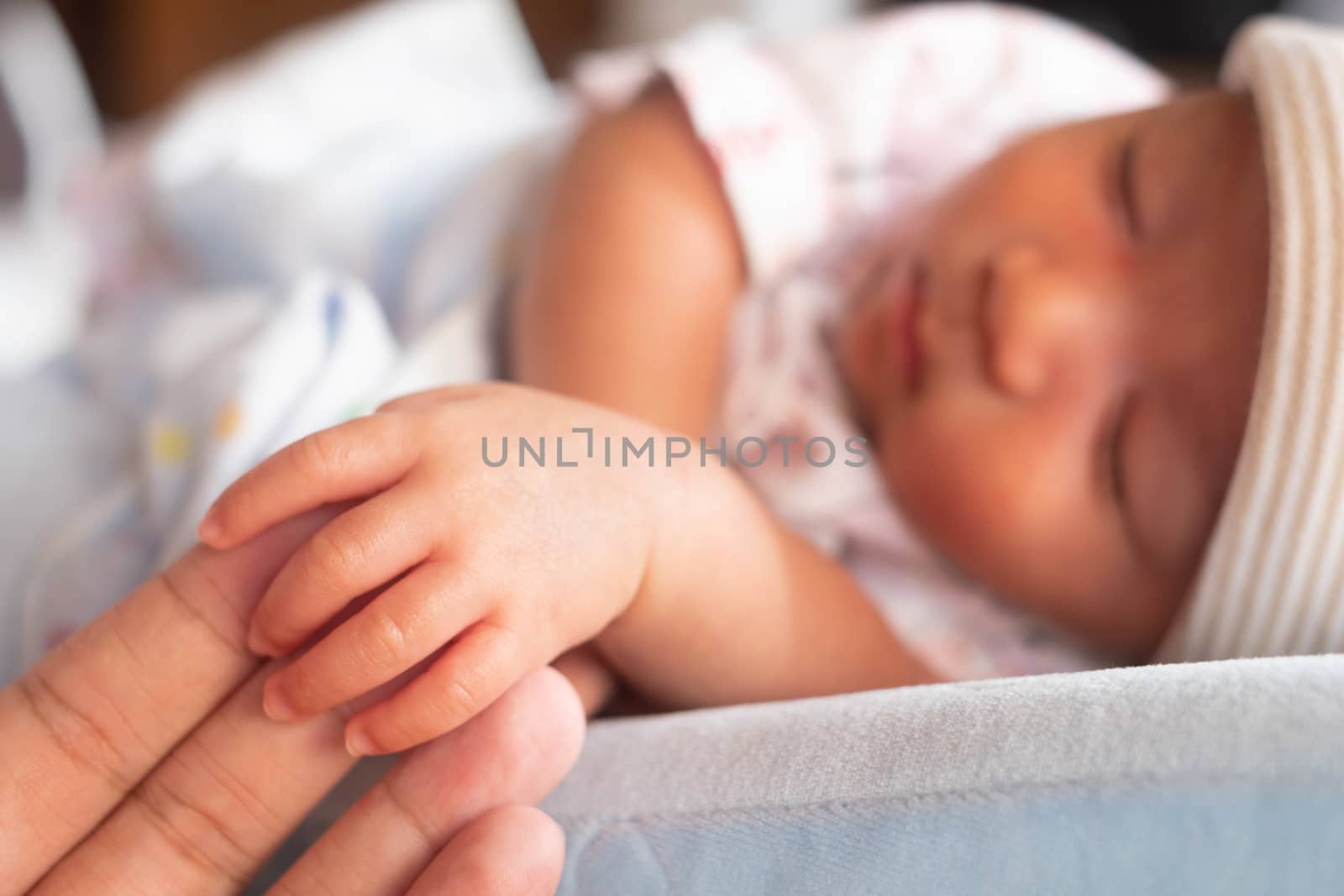 The newborn baby infant small hand holding father hand