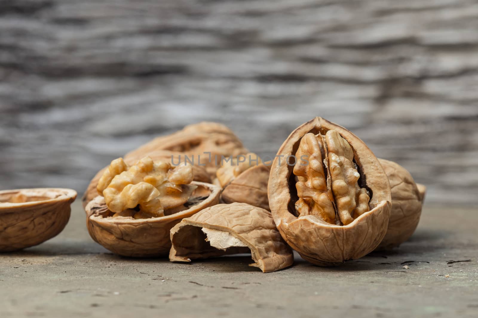 still life with Walnut kernels and whole walnuts on rustic old wooden table.