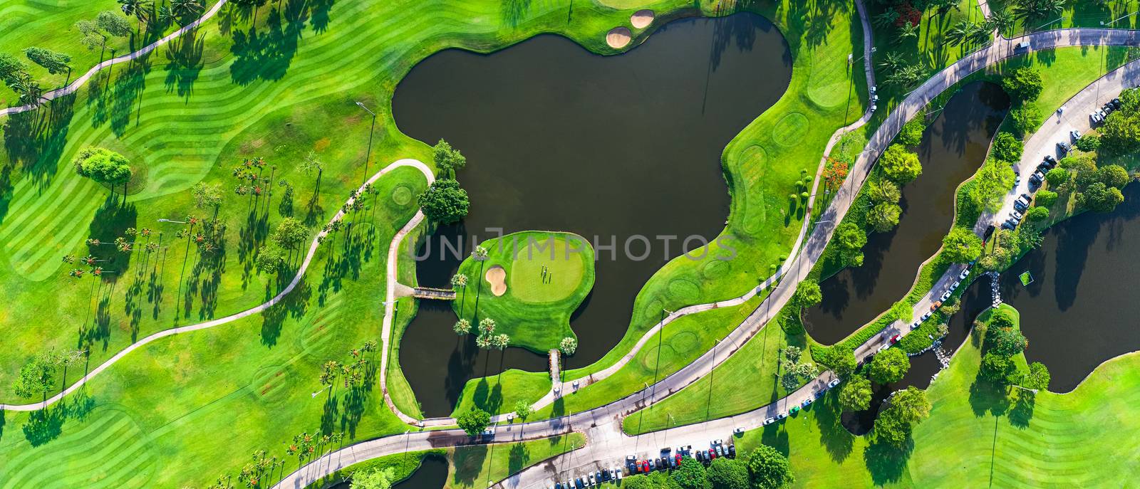 Aerial view of golf field landscape with sunrise view in the mor by PlottyPhoto