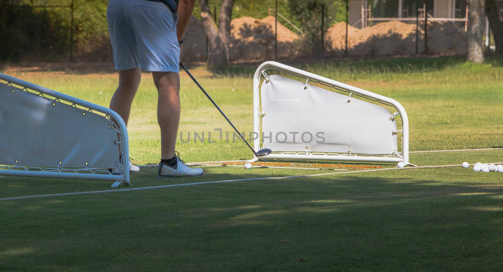 golf player making a swing with a golf  fairway wood course on the golf practice