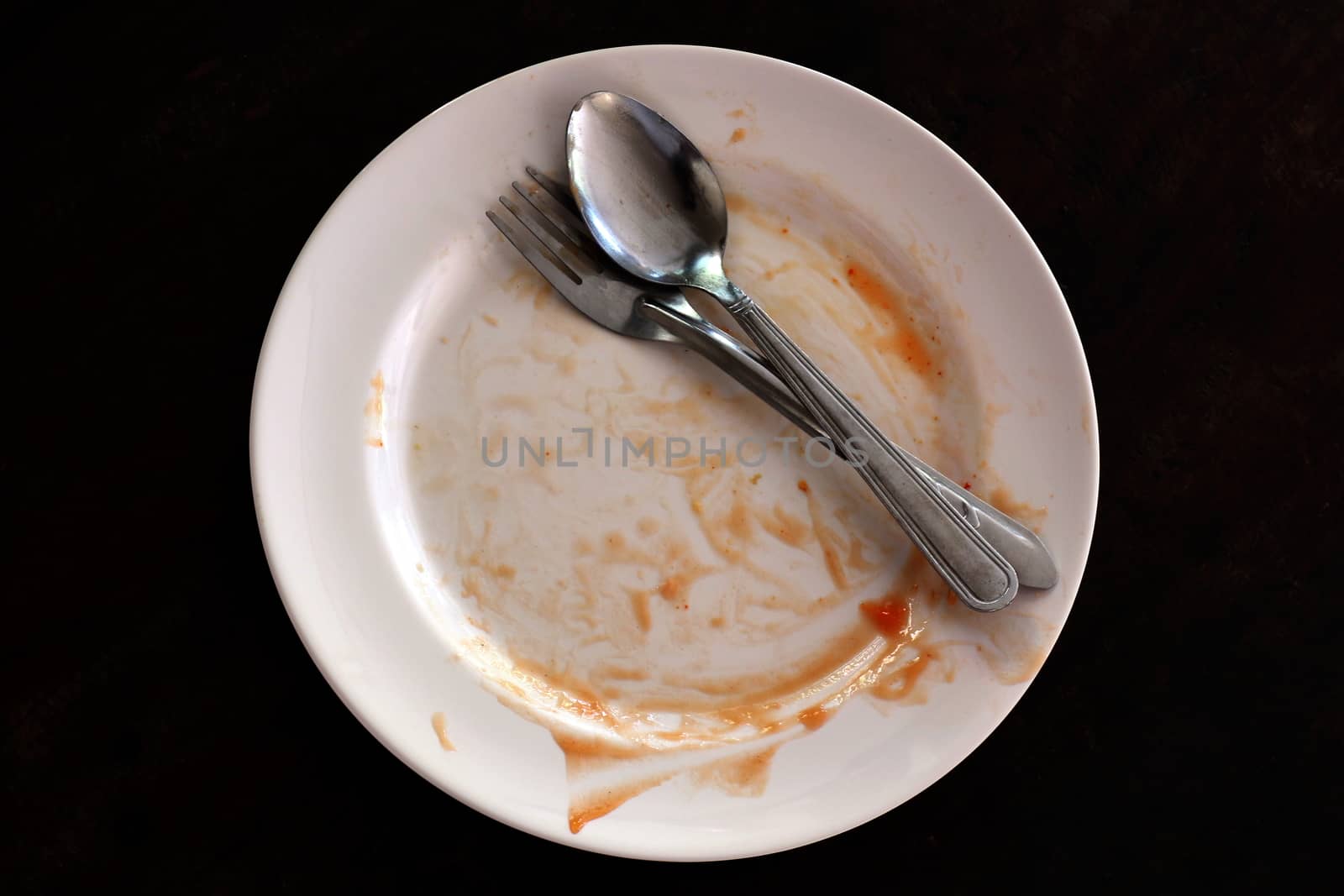 empty and dirty dish after eating food, plate fork and spoon