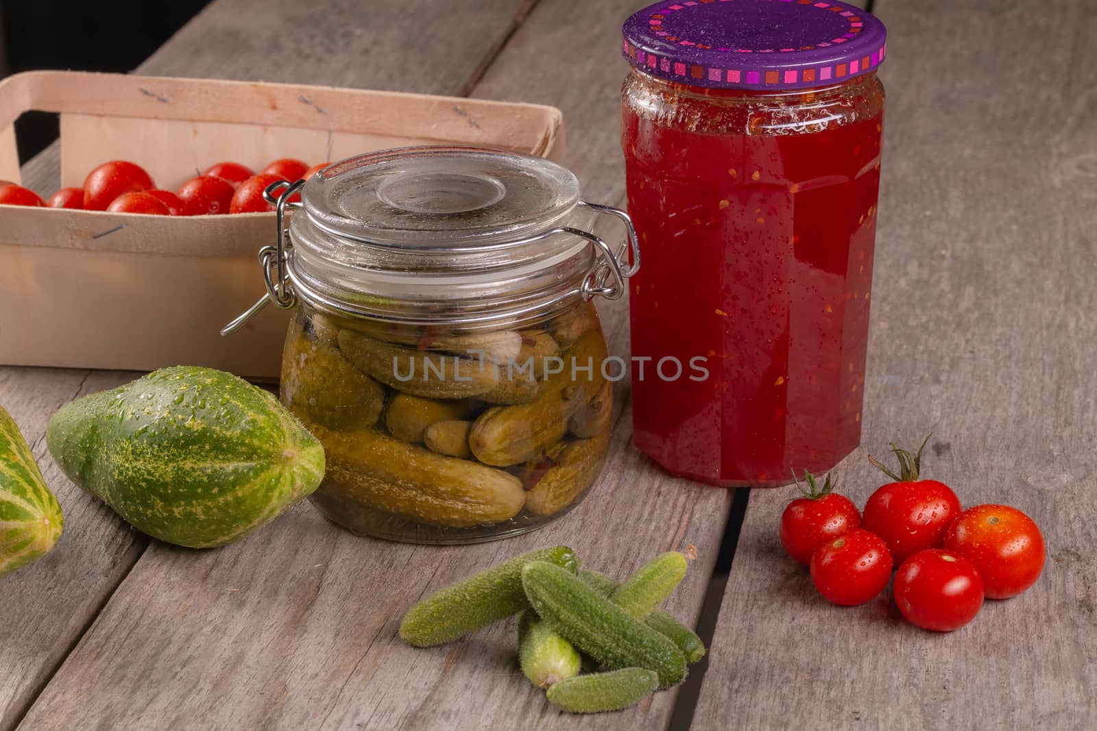 cucumber tomatoes cherry tomato jam canned corinichons on wooden background in studio