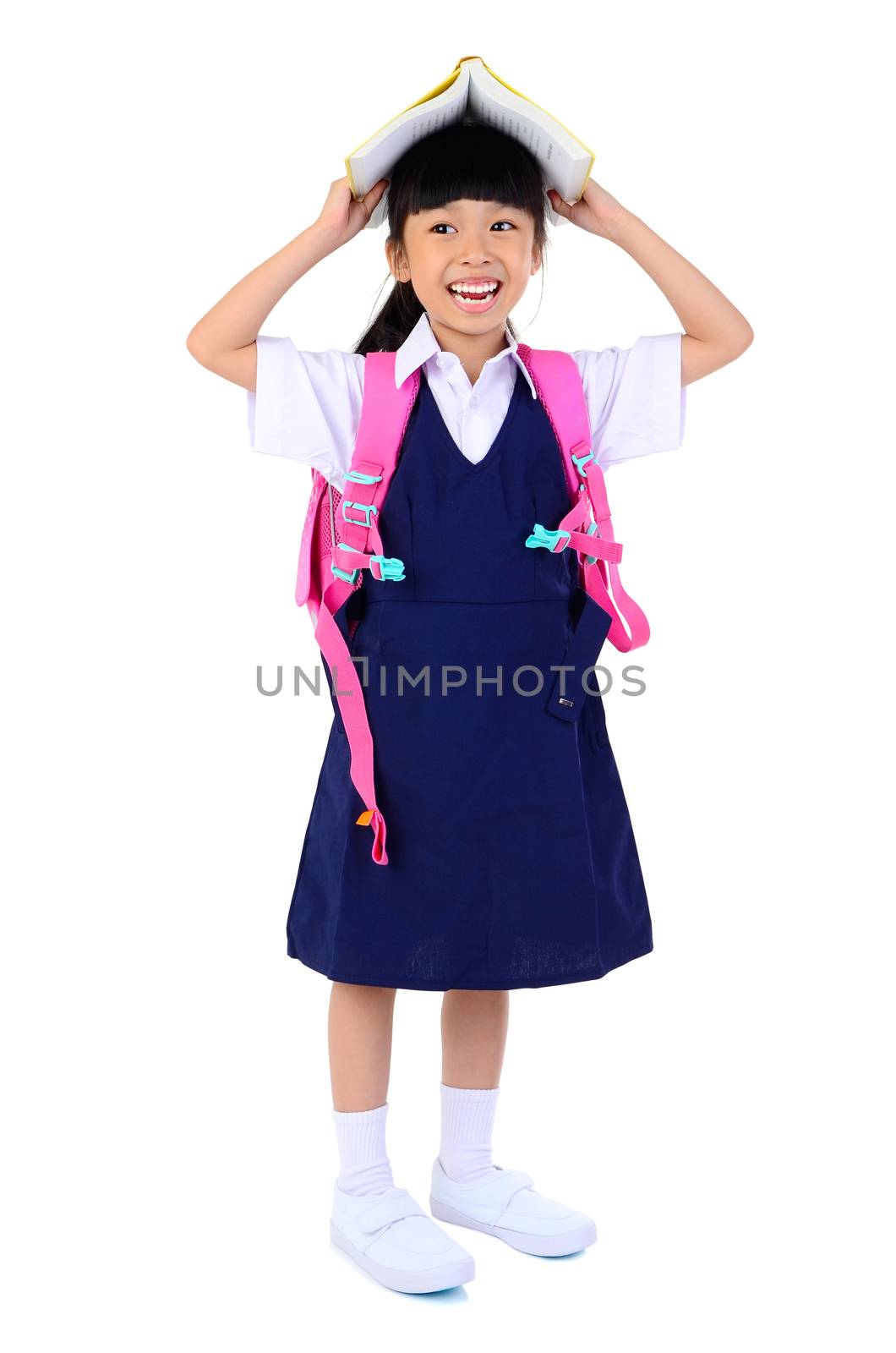 Portrait of Asian child in school uniform with school bag on and holding a book white background isolated.