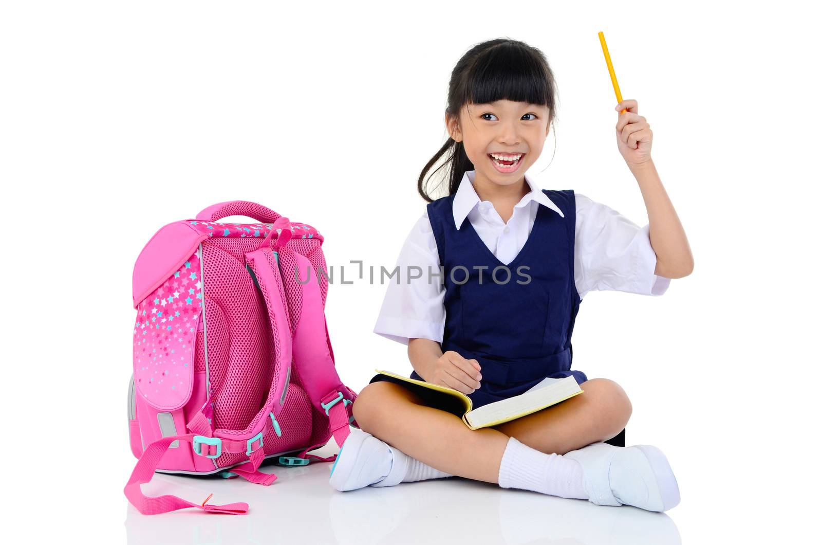 Happy little schoolgirl with books and bag,holding a pencil , isolated on white background