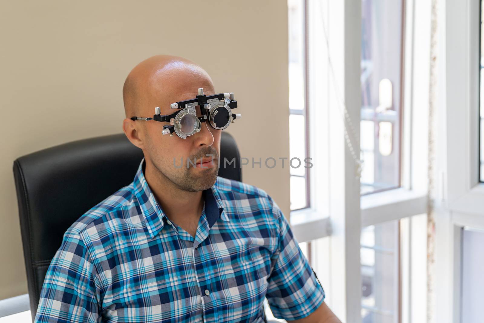 vision measurement by optometrist at clinic, young man as patient by Edophoto
