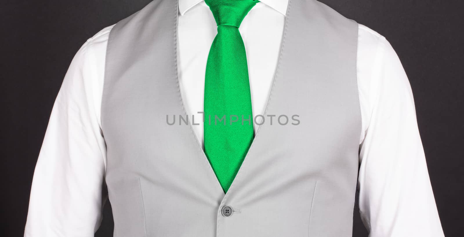 Man in a grey suit with green tie, close-up