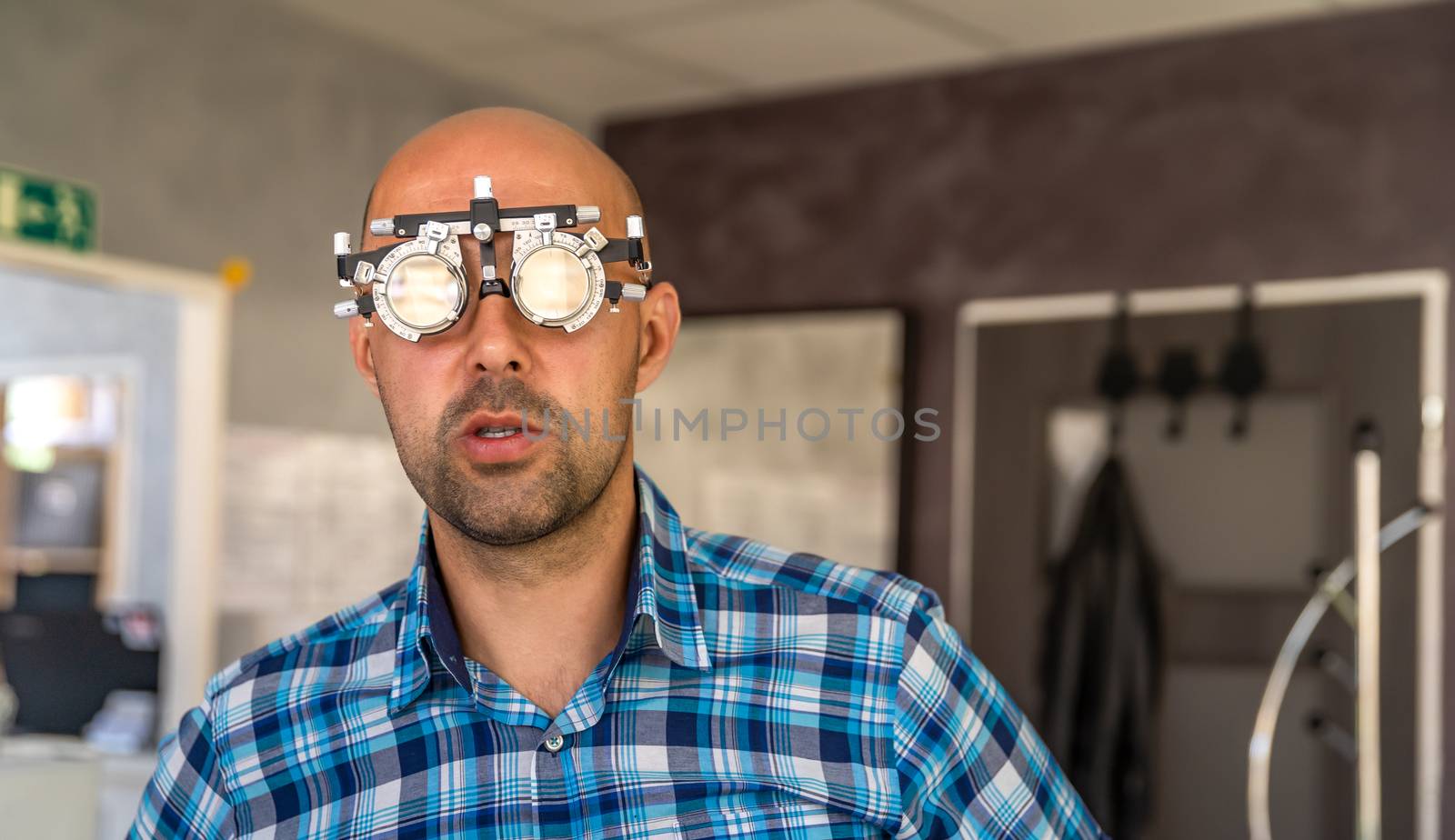 vision measurement by optometrist at clinic, young man as patient.