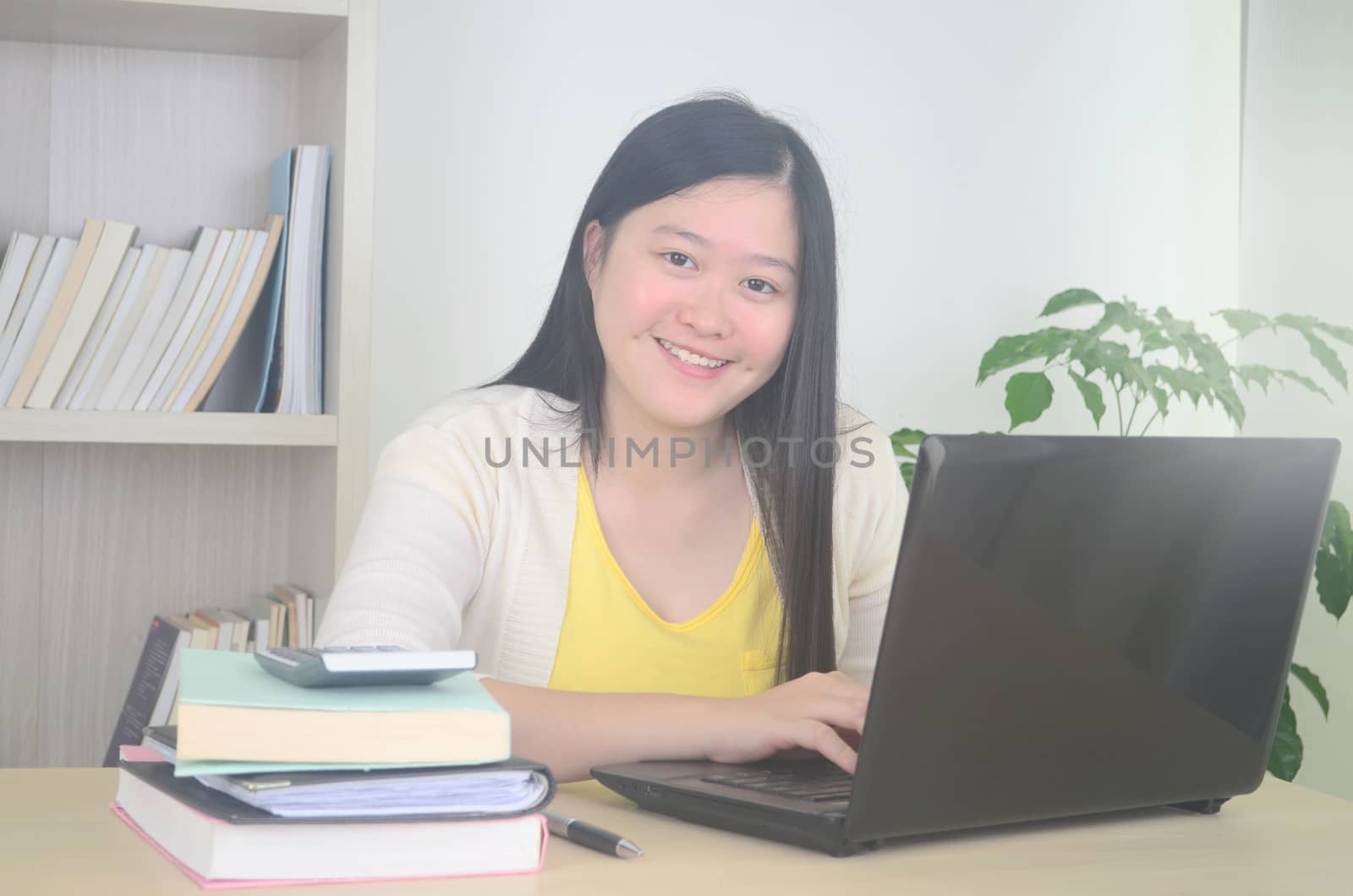 Smiling young woman working on laptop and quarantine at home.Work from home and social distance concept on virus corona pandemic.