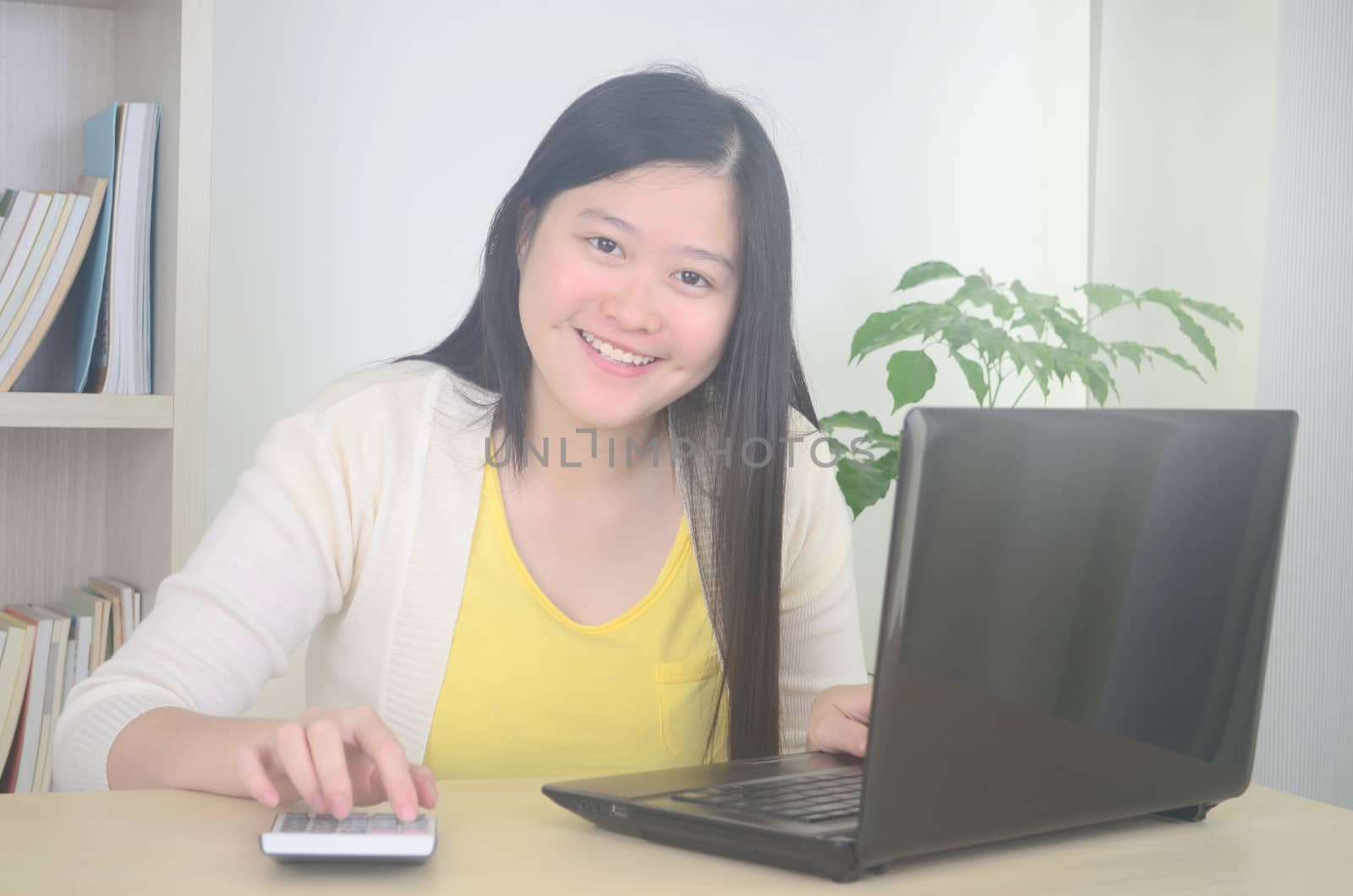 Smiling young woman freelancer working remotely from home while talking on phone.Work from home and social distance concept on virus corona pandemic.