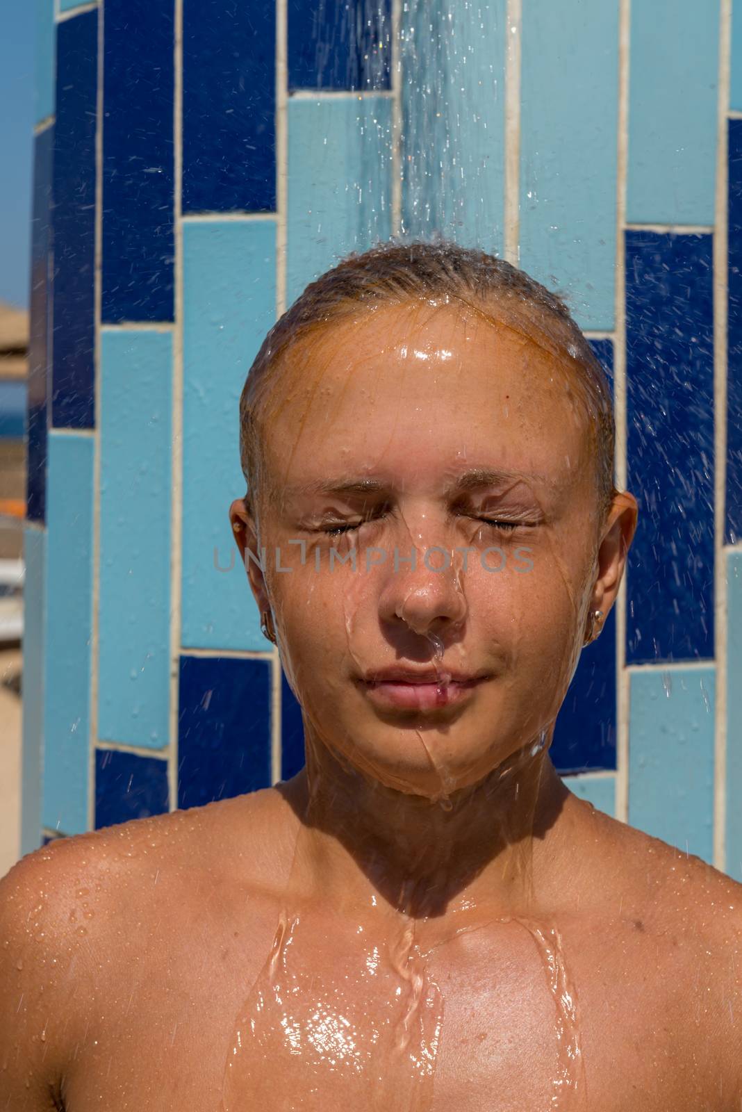 Sensuous slim woman taking shower at the beach