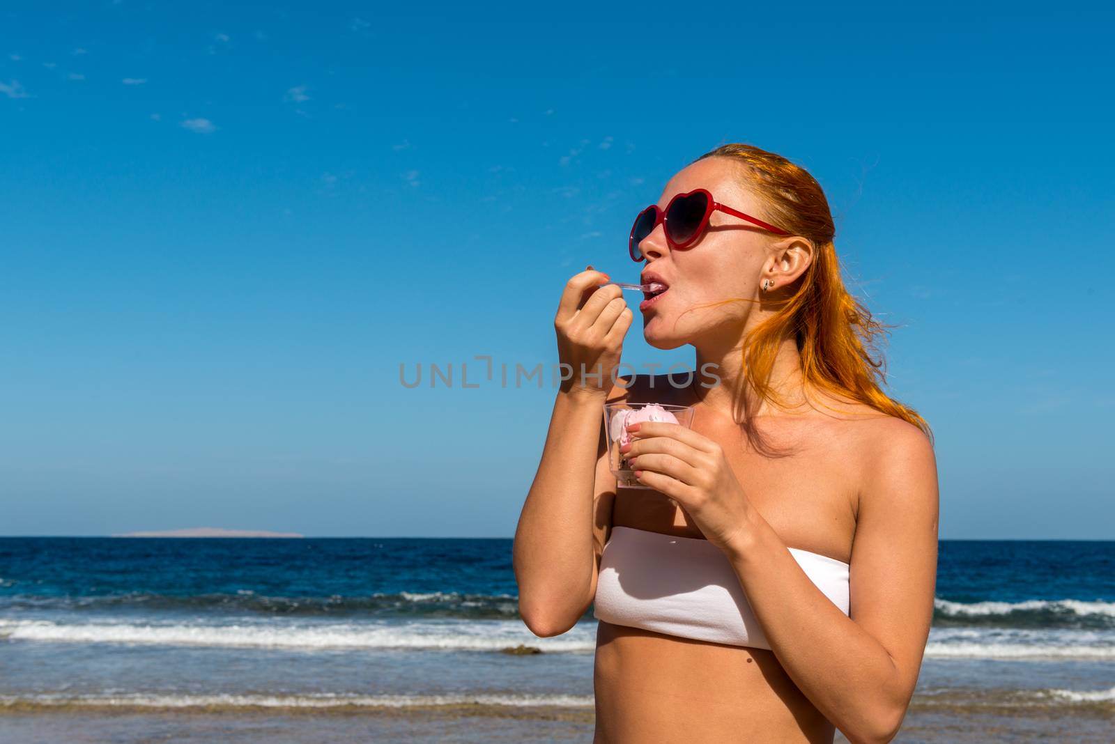 Young smiling woman holding ice cream by nikitabuida
