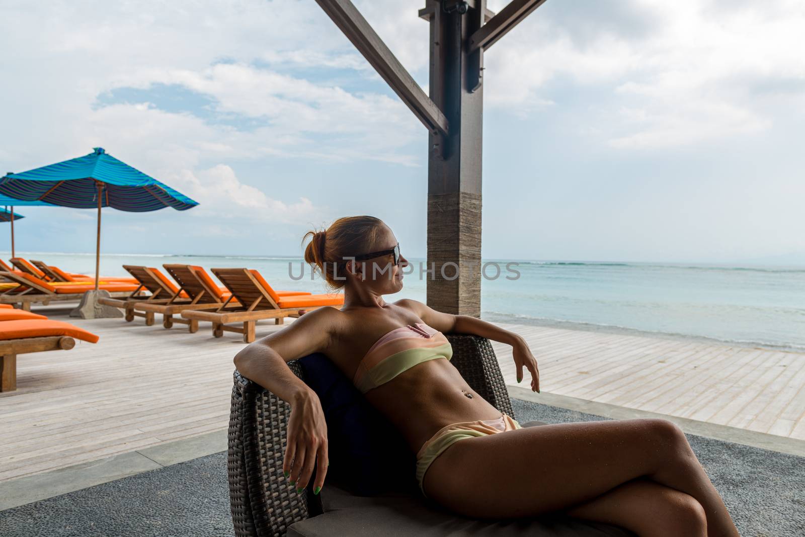 Young woman relaxing at the beach bar by nikitabuida