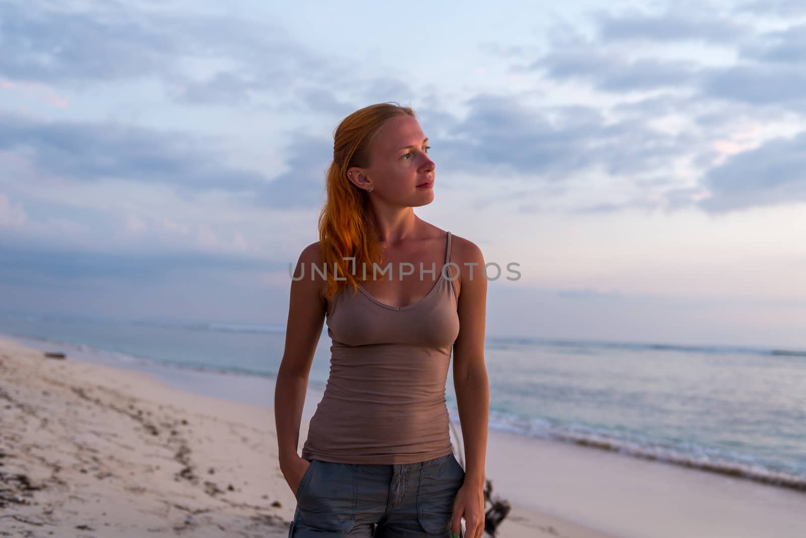 Young woman enjoying sunset view at tropical island beach