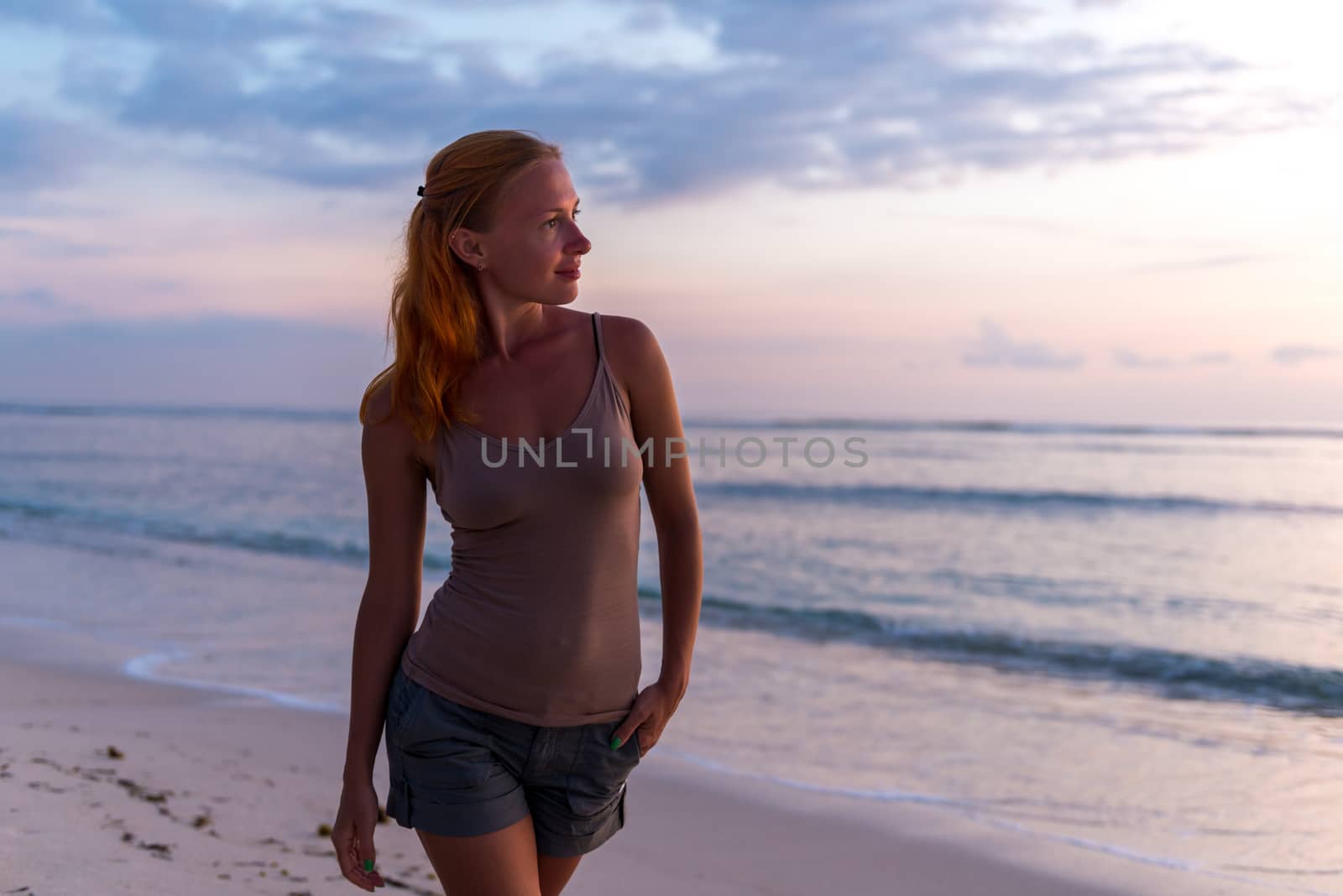 Young woman enjoying sunset view at tropical island beach