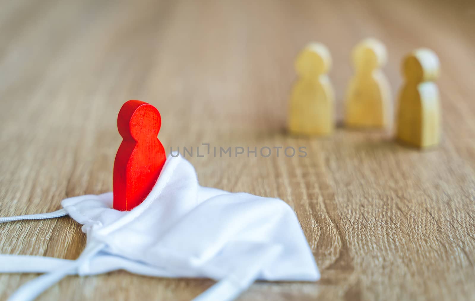 Social distancing during the Corona virus outbreak, red wooden Figure were infected in hygienic masks such as 
quarantine Exclude from people who are not infected to prevent increased outbreaks