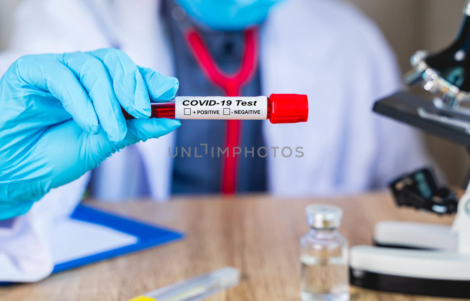 Close up The doctor's hand holds the patient's blood test results to find the Coronavirus or Covd-19 that is an outbreak in Epidemiology or infectious concept with blur background