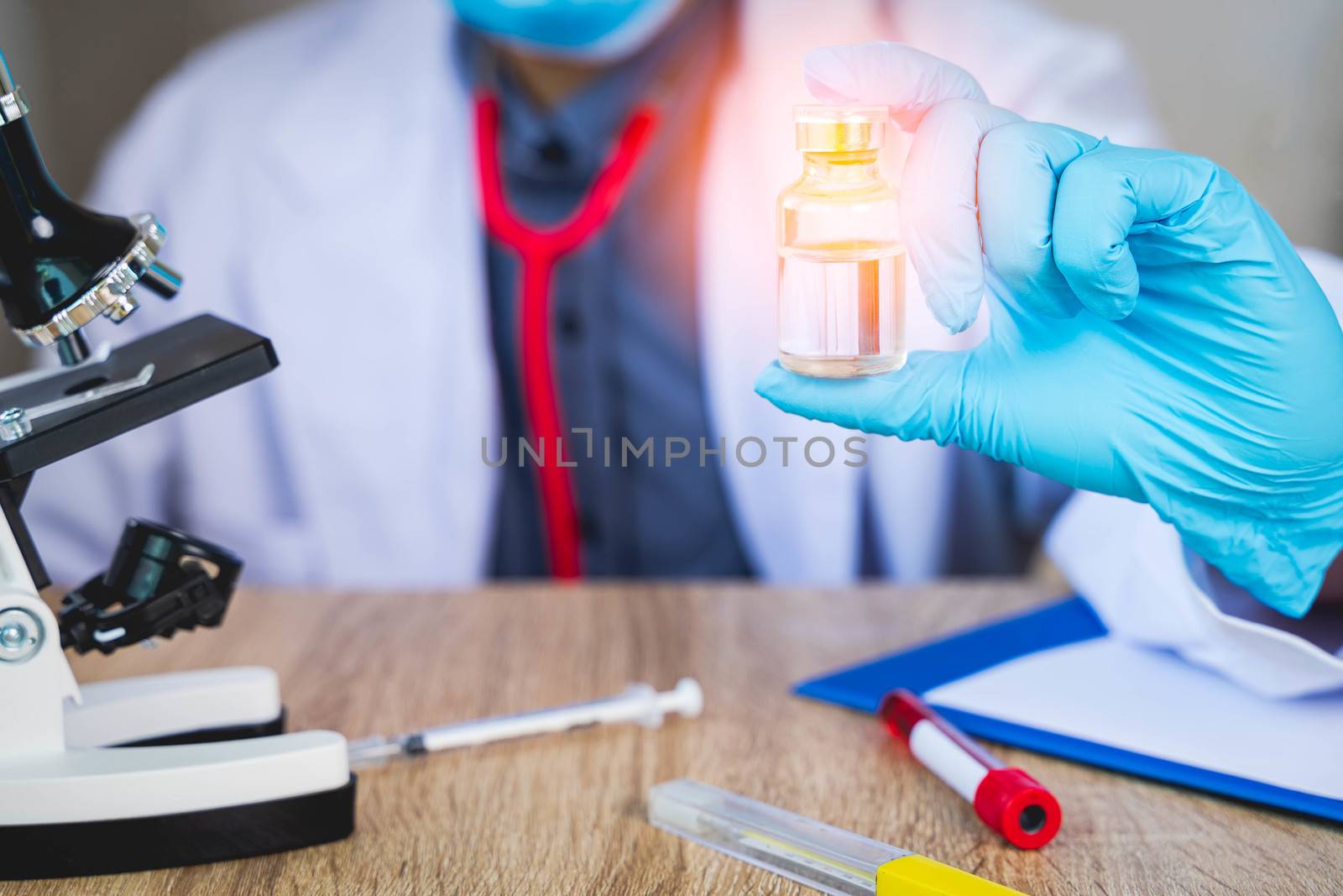 Close up The doctor's hand holds a bottle of vaccination pills. For the treatment of the virus that is being infected or infectious concept with blur background