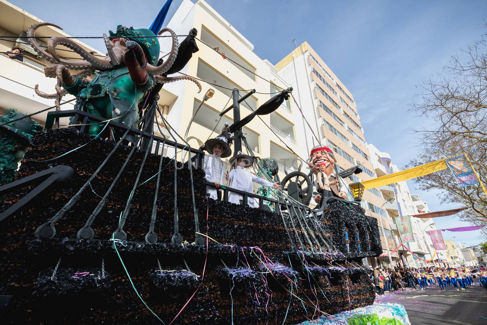 Loule, Portugal - February 25, 2020: Pirate ship float parading in the street in front of the public in the parade of the traditional carnival of Loule city on a February day