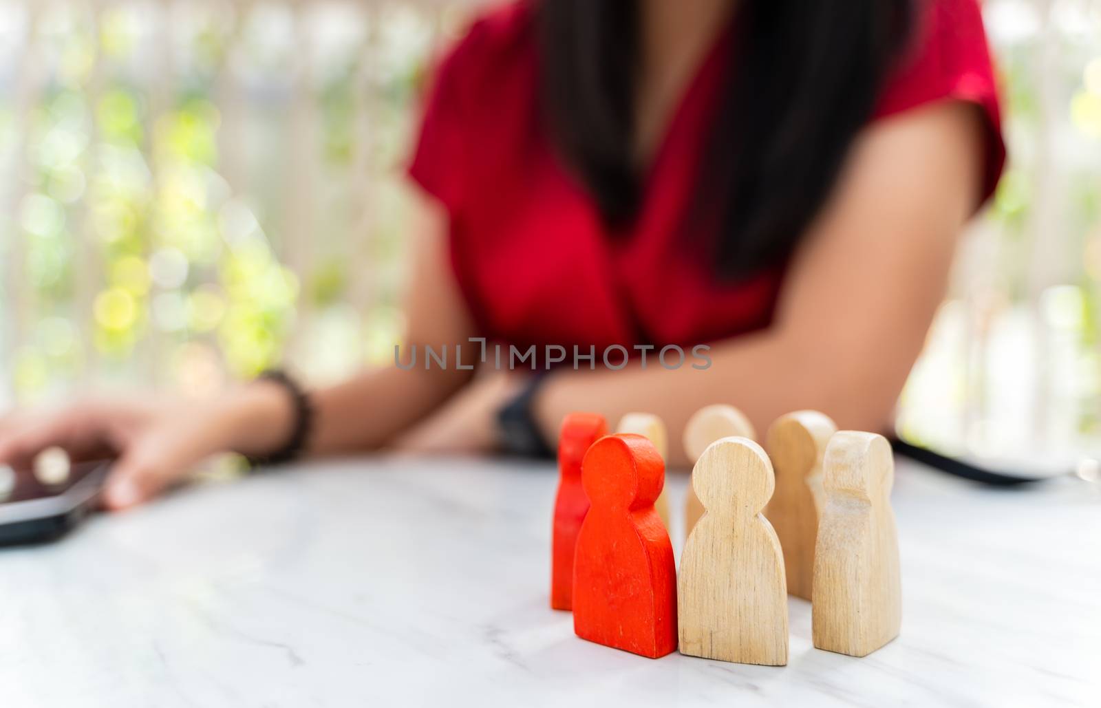 Figure in human resource management concept. The group of wooden puppets is a circular. A red wooden figure like an dominant in a group with blur owner or manager background
