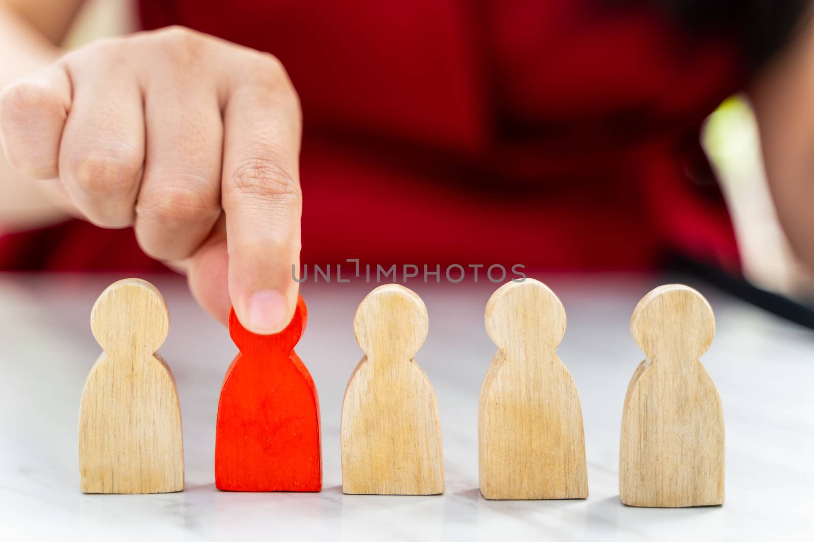 Figure in human resource management concept. The red wood figure was picked out of its group. Red Wood figure like who is selected from the candidate, or choose the most dominant in the team