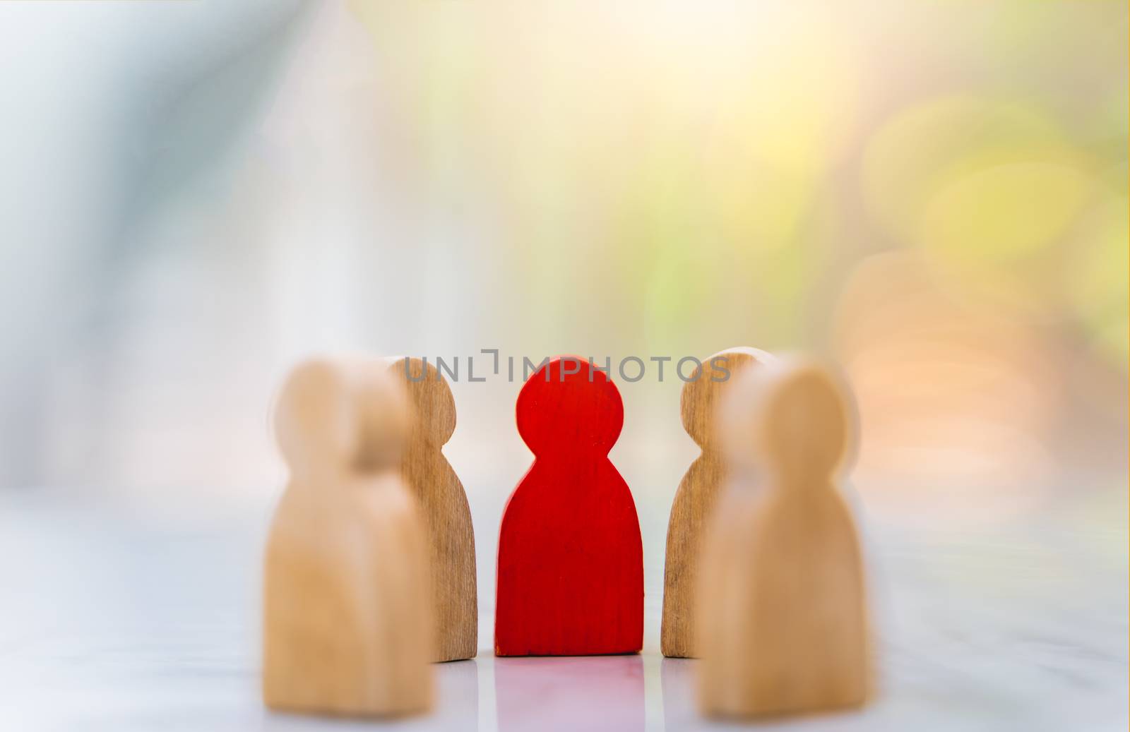 Figure in human resource management concept. The group of wooden puppets is a circular. A red wooden figure like an dominant in a group with blur bokeh background
